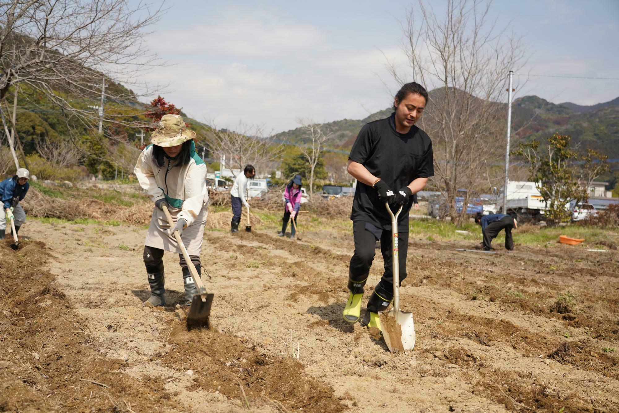 佐賀県神崎にある畑で『原点回帰』メンバーと一緒に畝作りをする山田さん