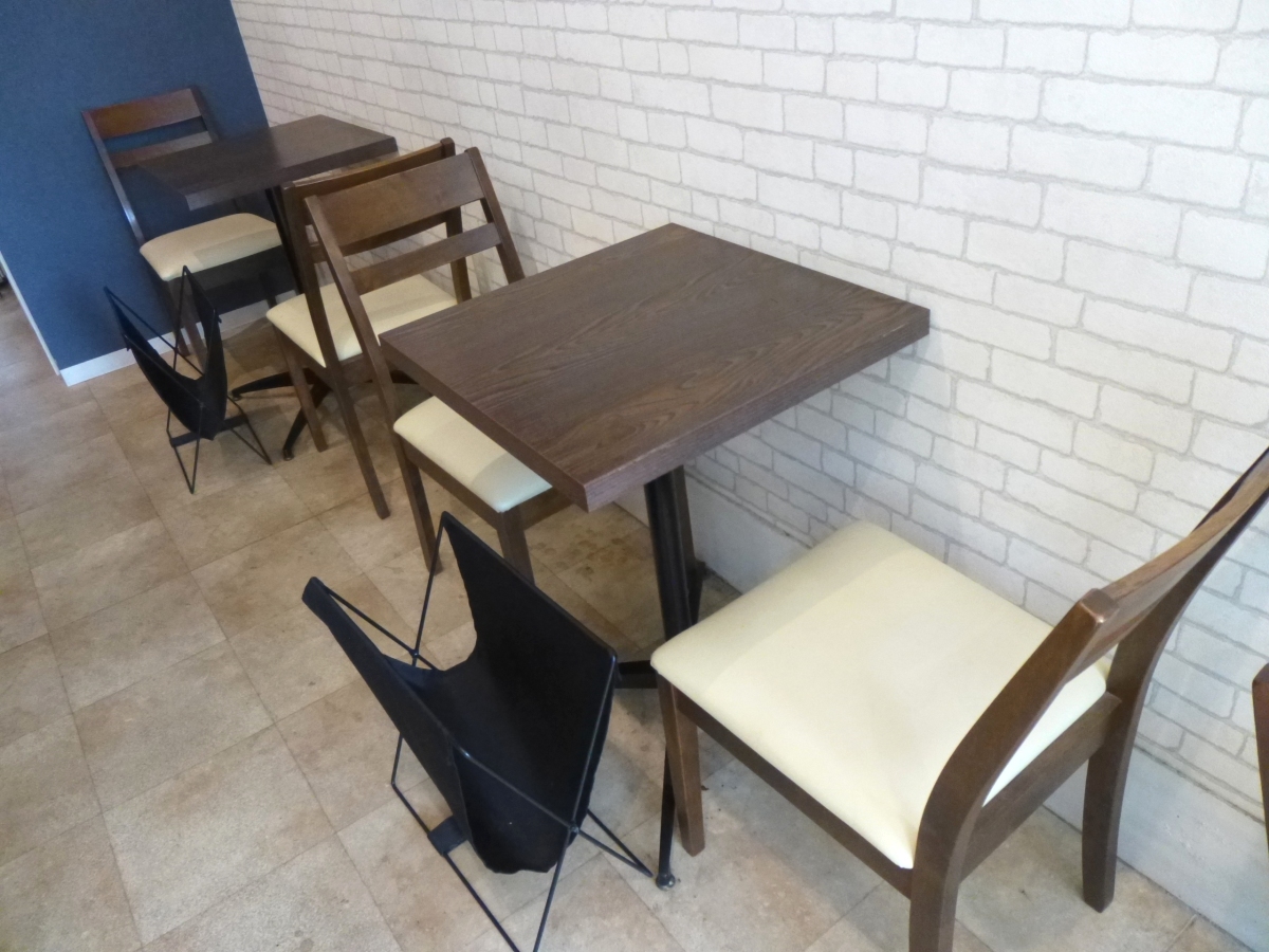 シンプルなテーブルセットと白いレンガ調の壁が瀟洒な店内