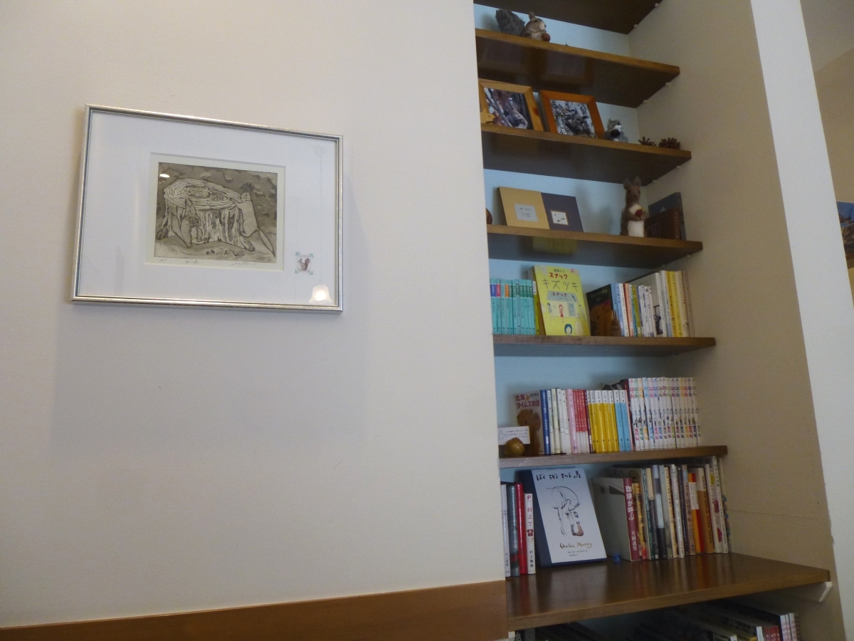 魅力的な本が並ぶ閲覧自由の本棚。壁にかかるエゾリスの絵も愛らしい。