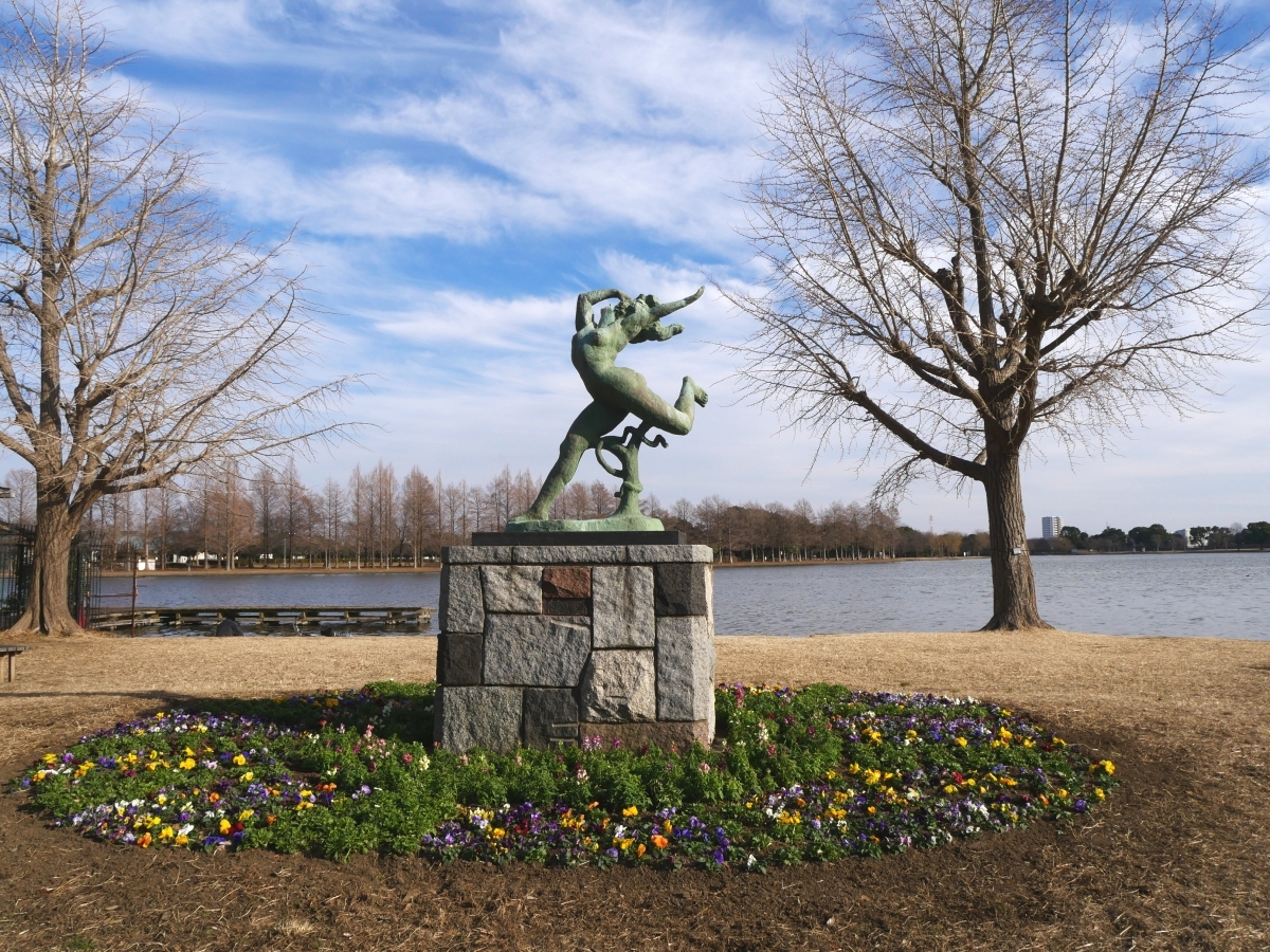 水元公園のシンボルの銅像と、足元で咲き揃う花々