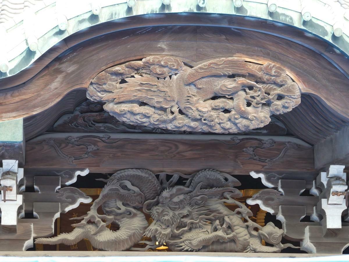 祖師堂の唐破風の先端とその下にいる龍の彫刻