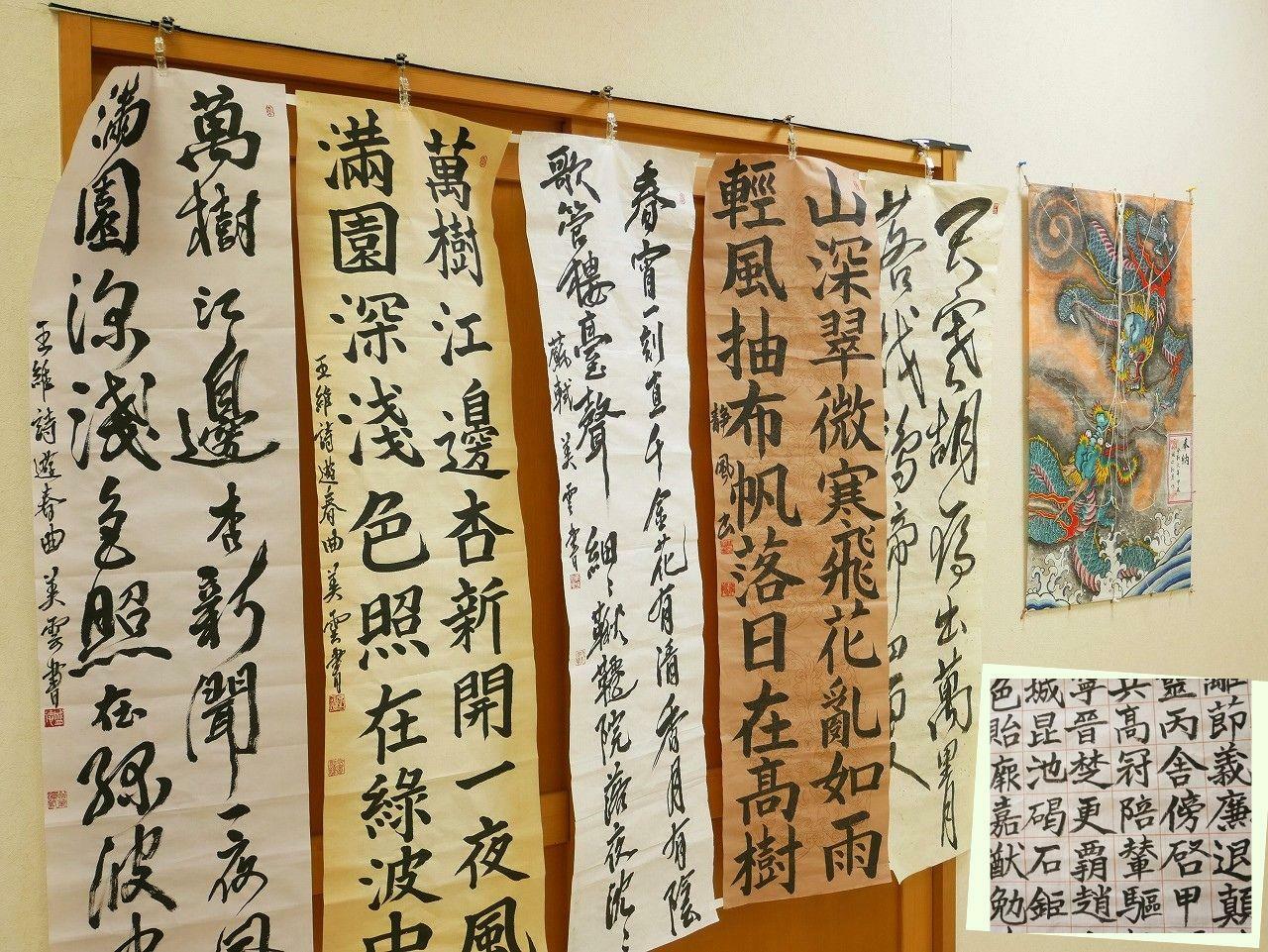 手前の壁には講師の作品を展示（画像中央は北宋（中国）の詩人・蘇軾が詠んだ七言絶句『春夜』（しゅんや）、右下は千字文（部分））