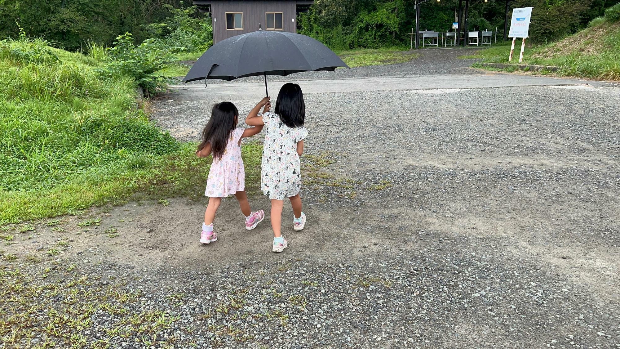 朝霧ジャンボリーで小雨の中次女と三女が傘を持ちたいと争い始める様子