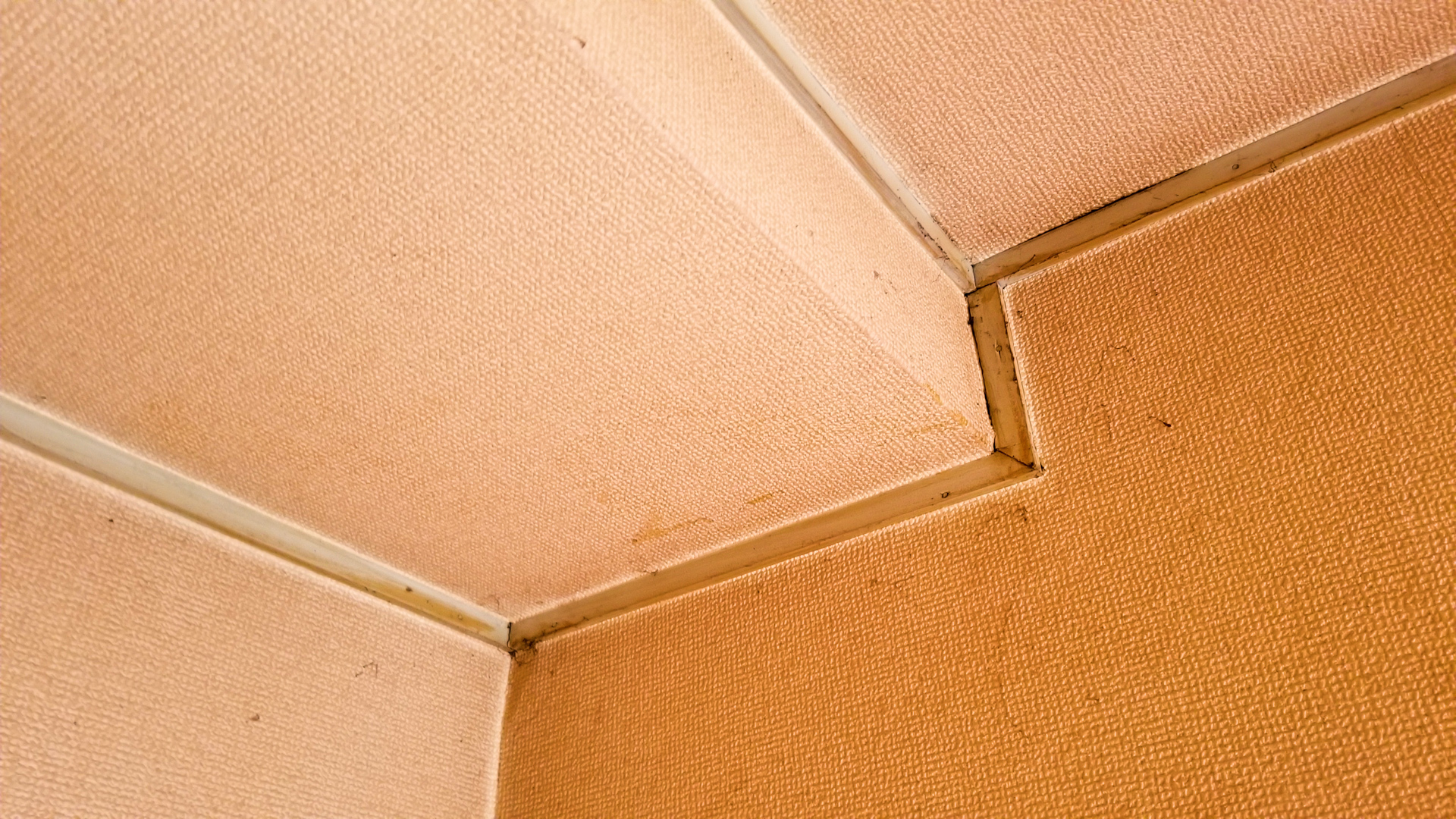 壁紙も茶色だけど、廻り縁と天井もヤニ汚れで染められてます