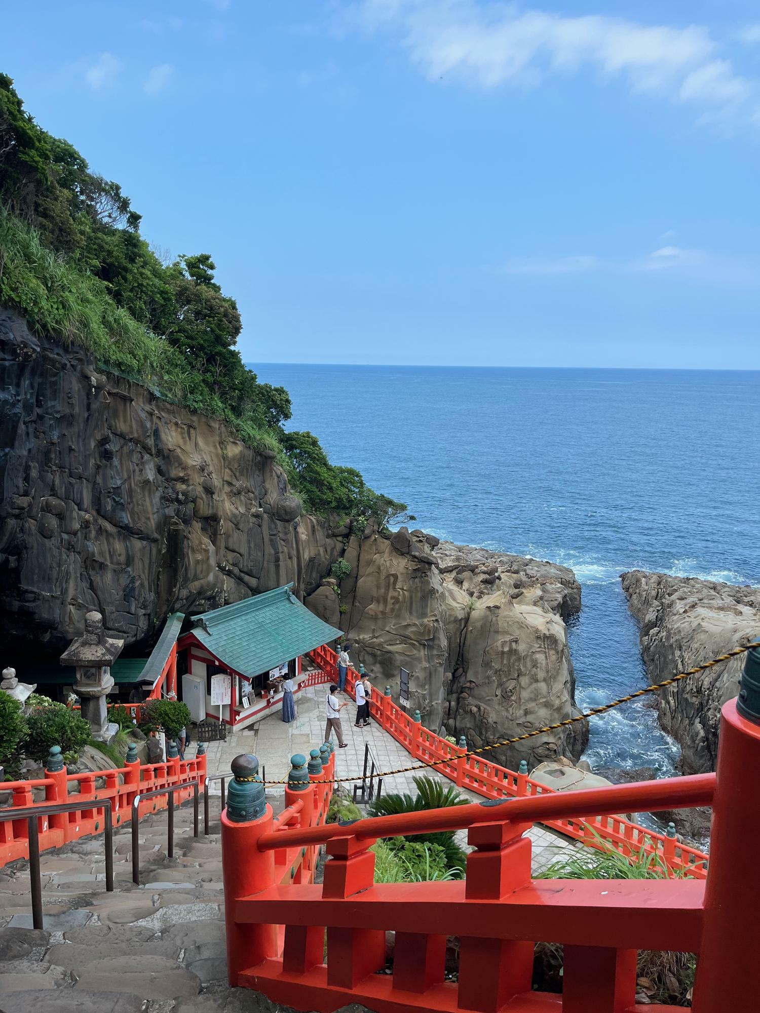神社の朱色と崖と海が同時に見られる絶景