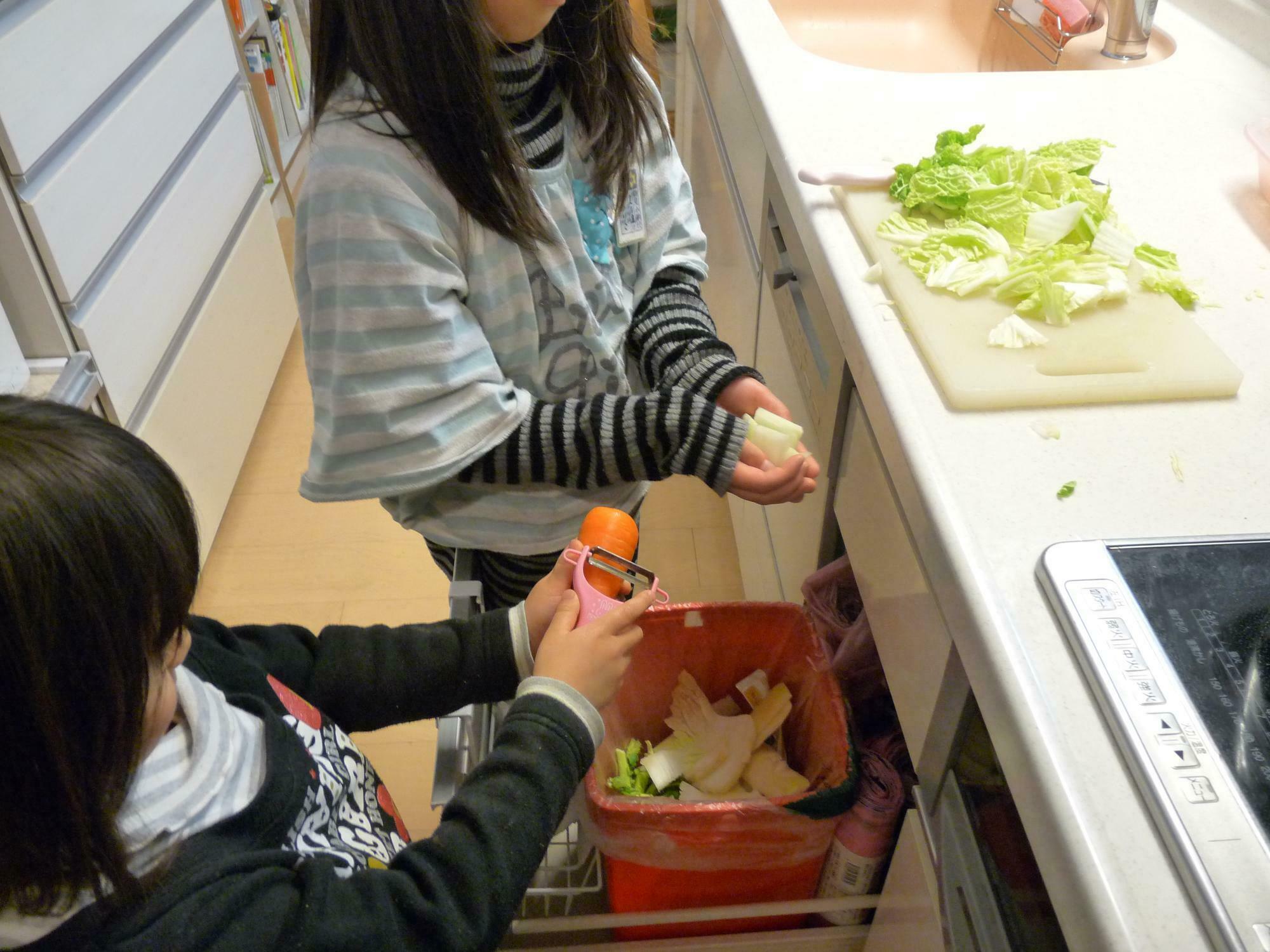 剥いた野菜の皮をそのままゴミ箱い入れる子どもたち。