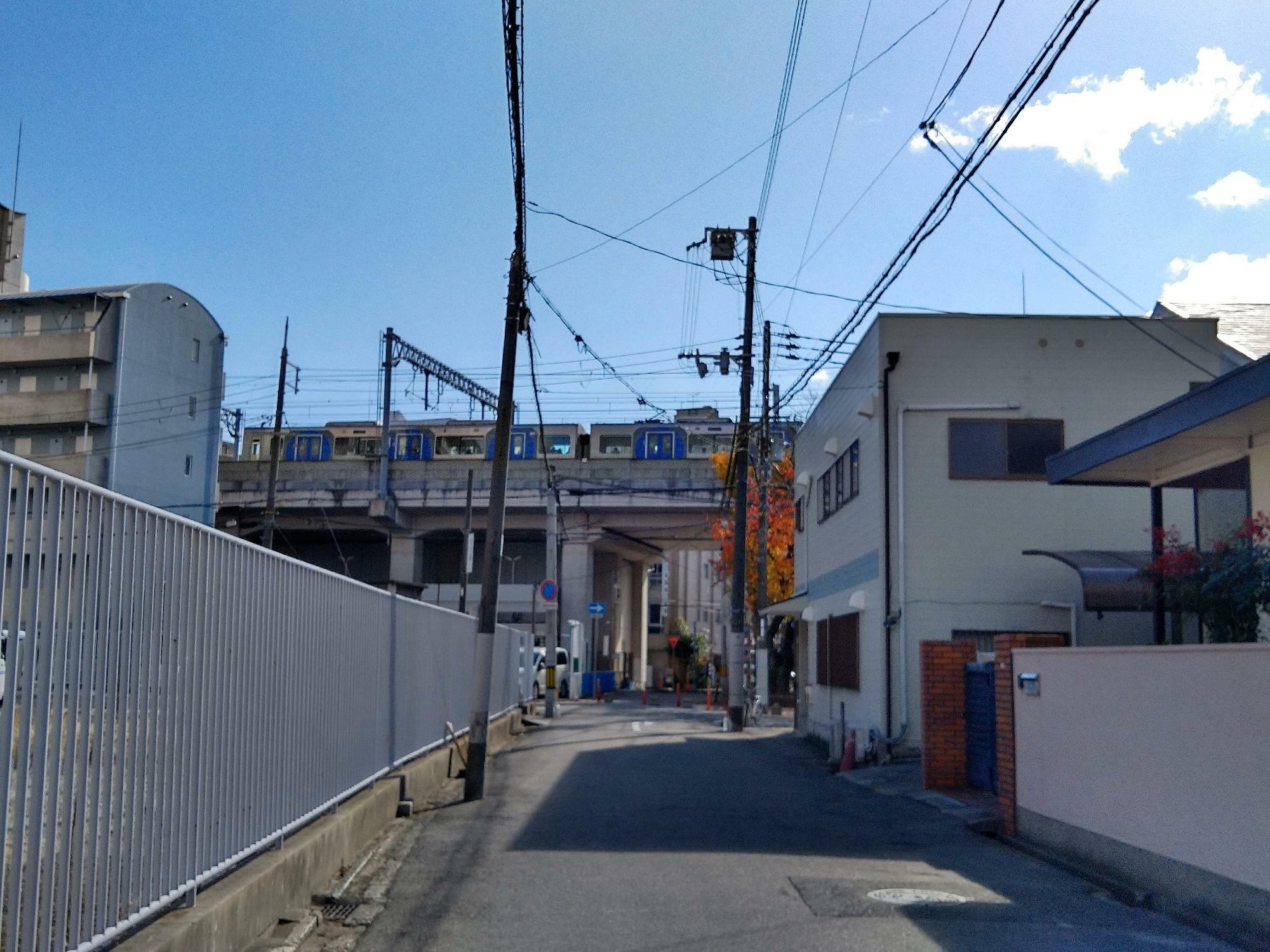 北側から「バンクシーアート」のある阪神電車の高架を臨む