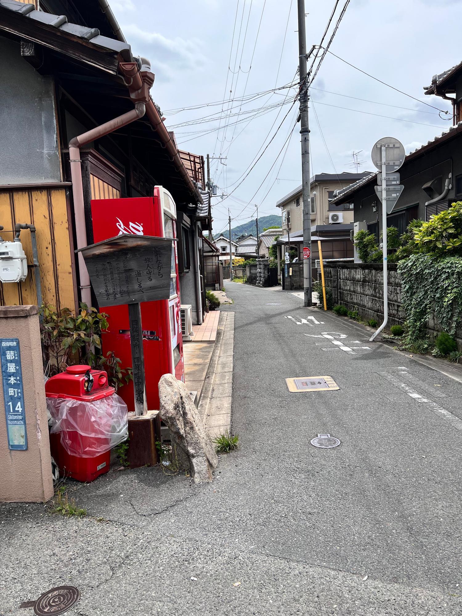 清滝街道の起点から東向きに撮影。左側に街道の起点であることを説明する立て札とその横に自然石の道標