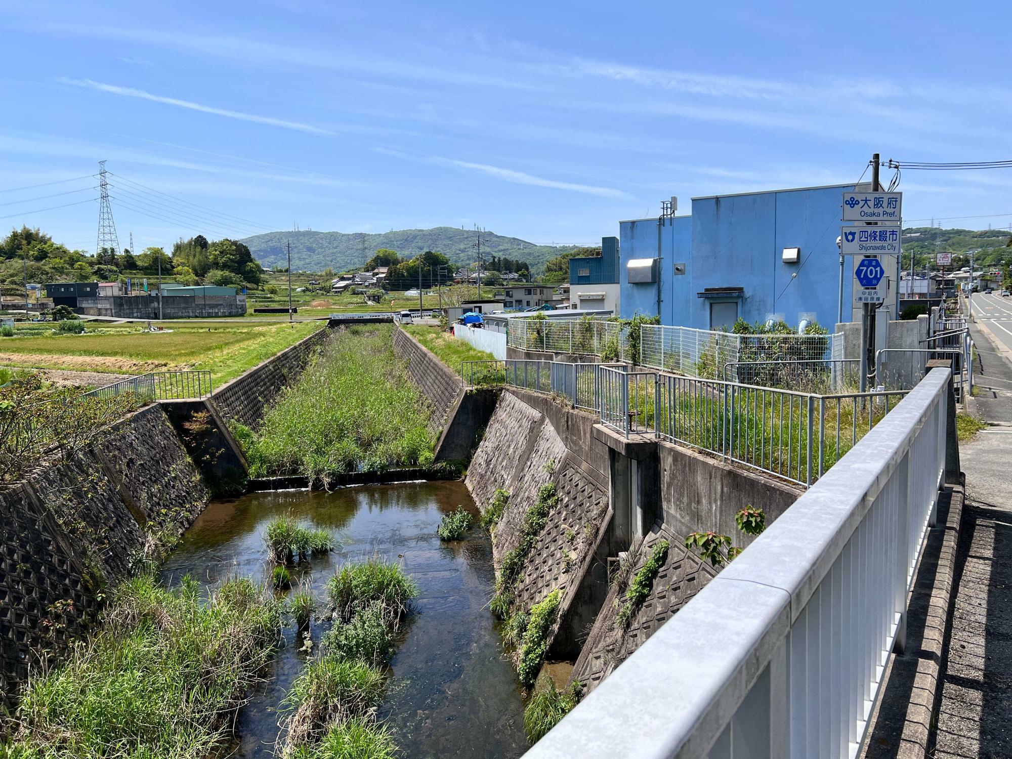 天野川に沿って府境があり、向かって右側は四條畷市、川よりも左側は生駒市