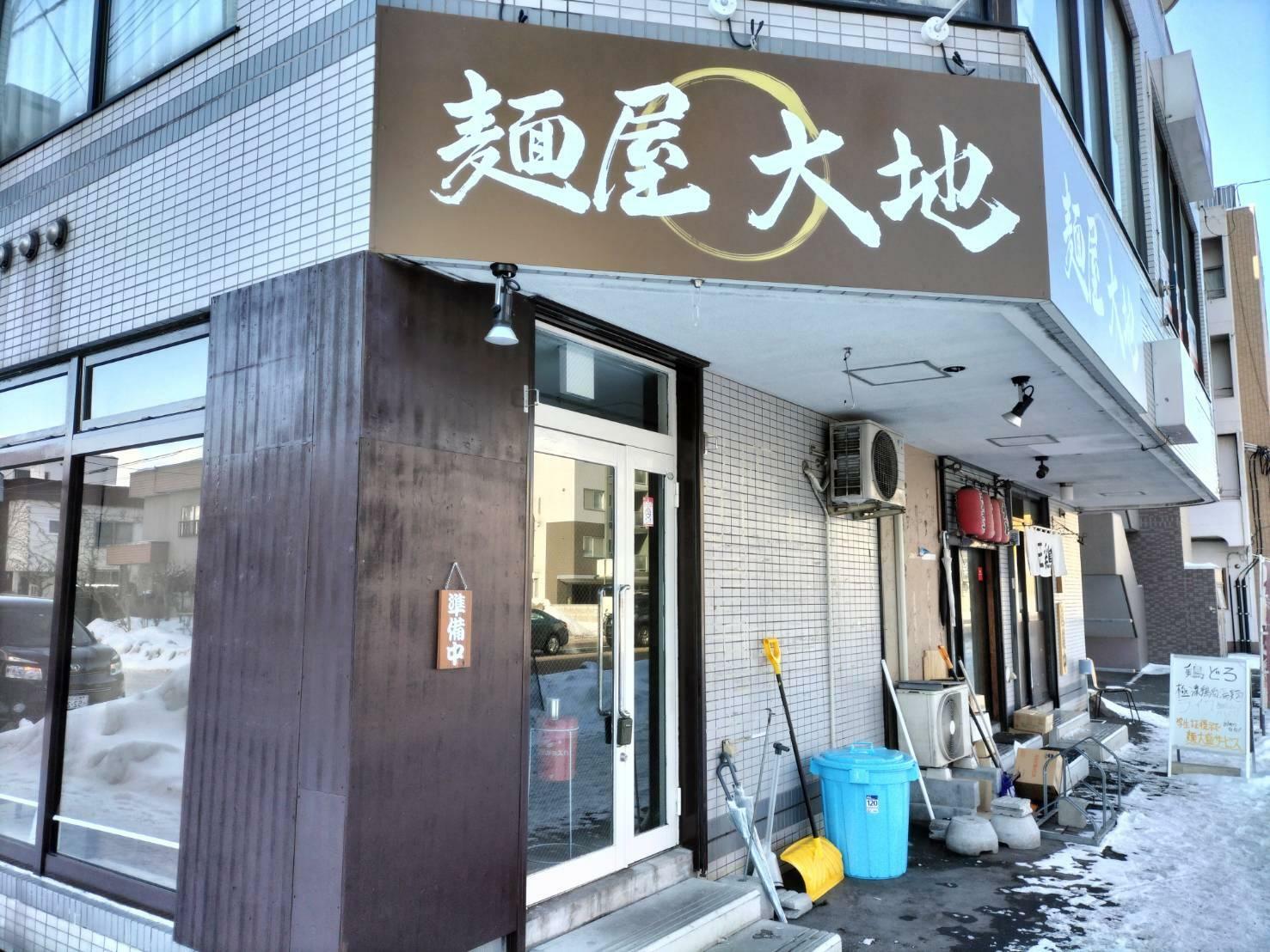 「麺屋大地」の奥に見える、白い暖簾のお店が「王鶏」（※2023年1月撮影）