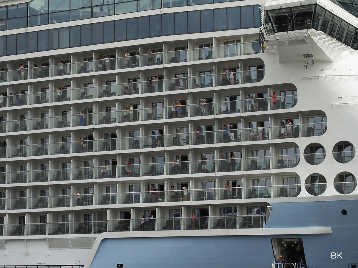 客室から神戸入港を眺める乗客。