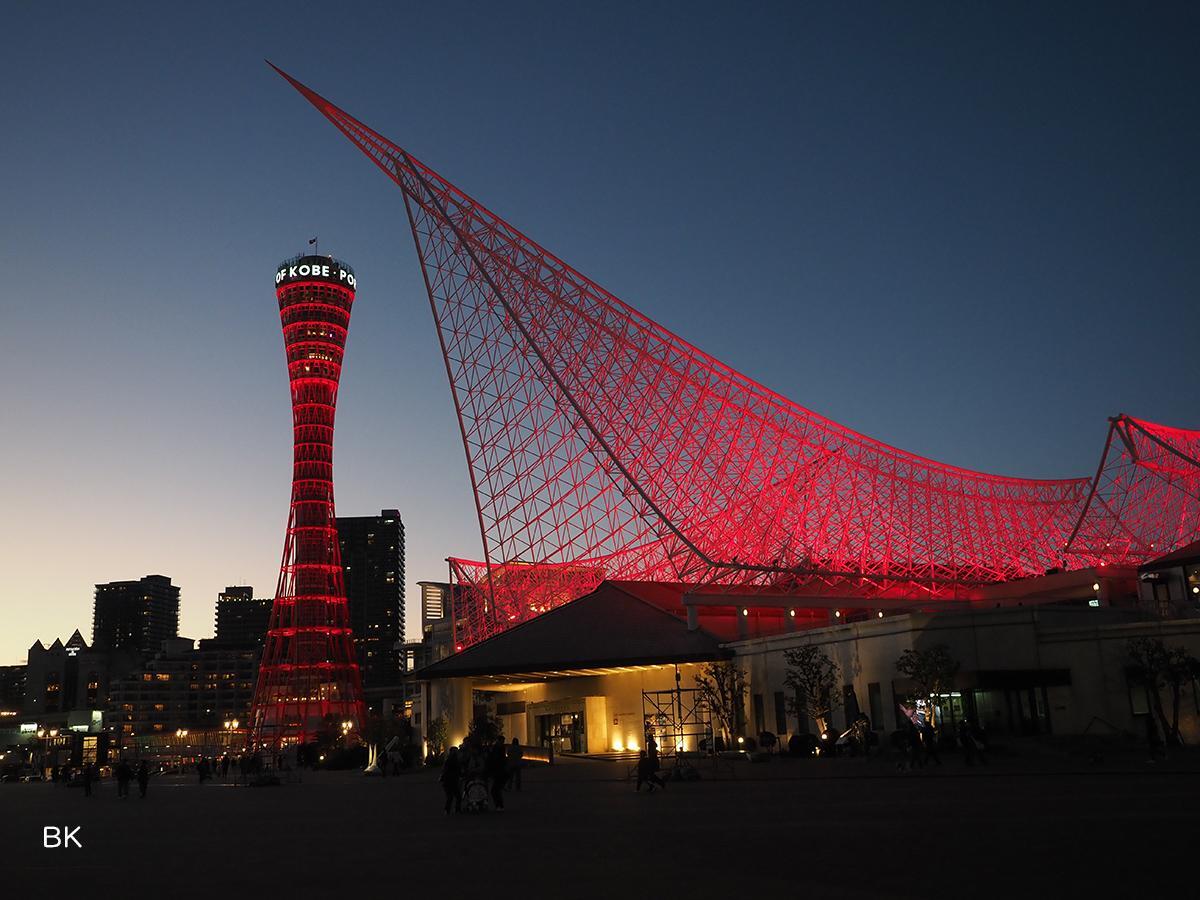 クリムゾンレッドのライトアップされたポートタワーと神戸海洋博物館。