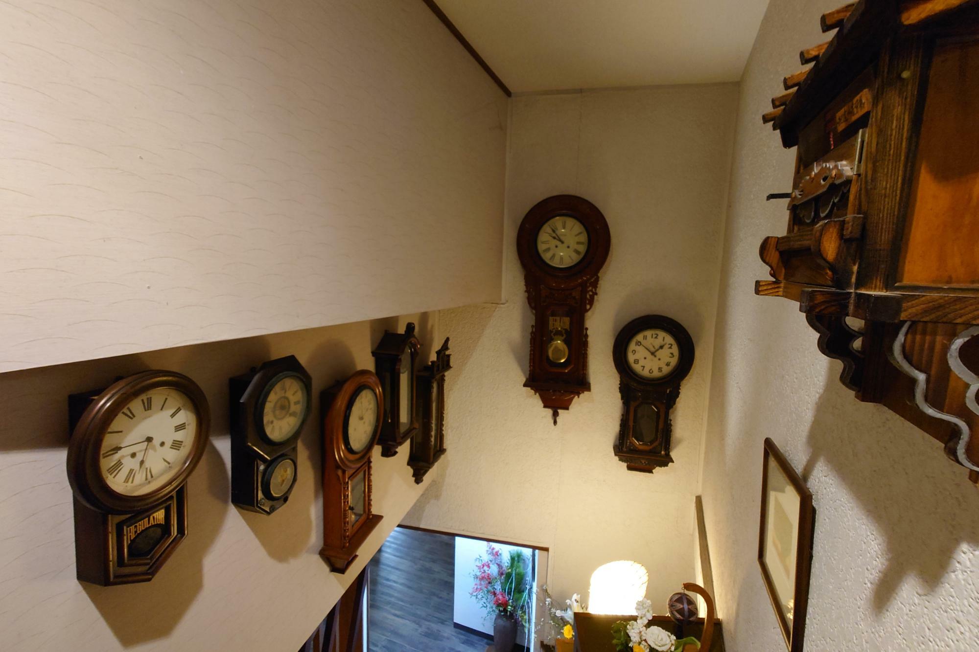 階段にたくさん飾られたレトロな時計
