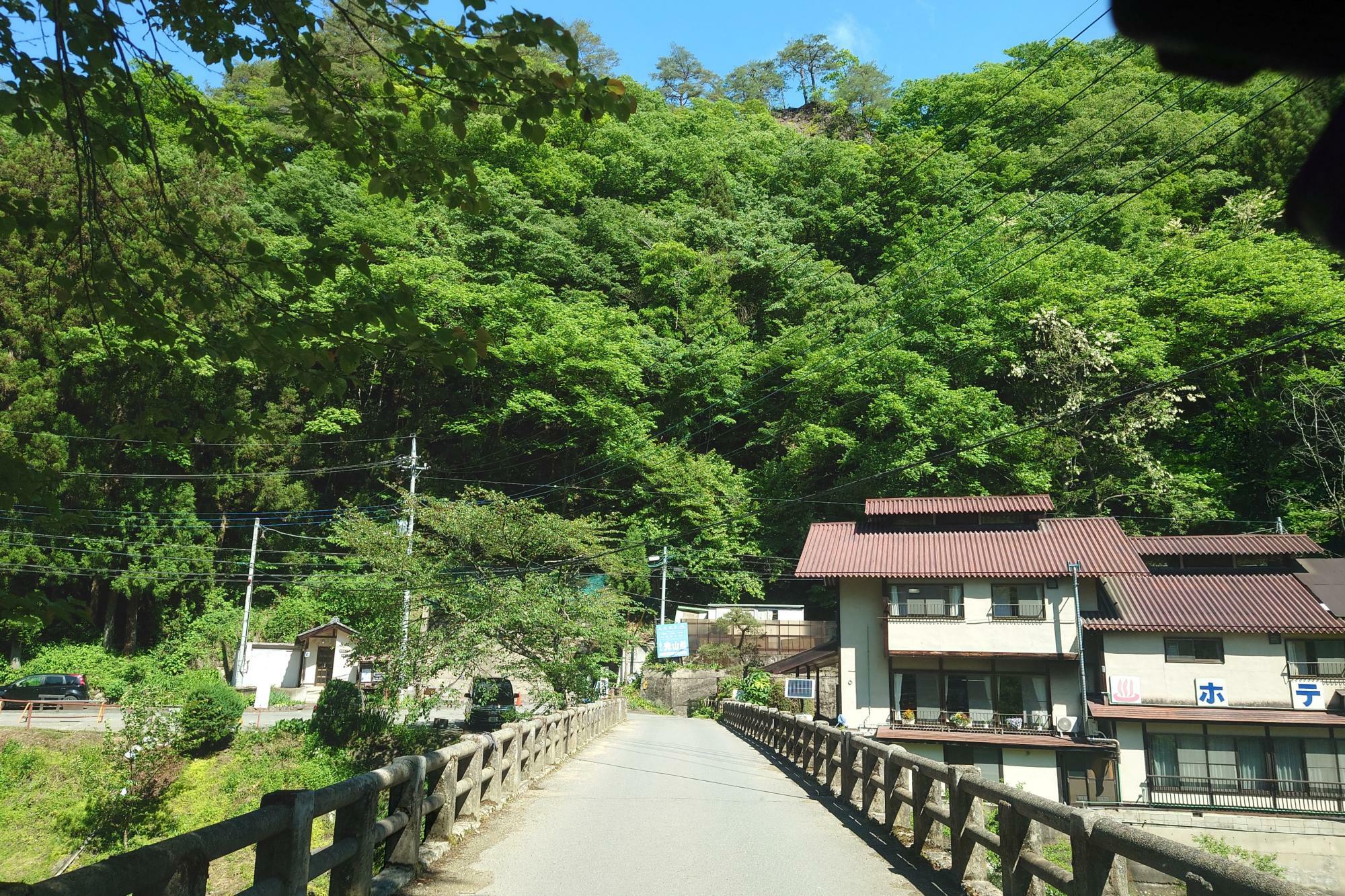 橋を渡って右前方に見えている建物は、尻焼温泉 ホテル光山荘です。