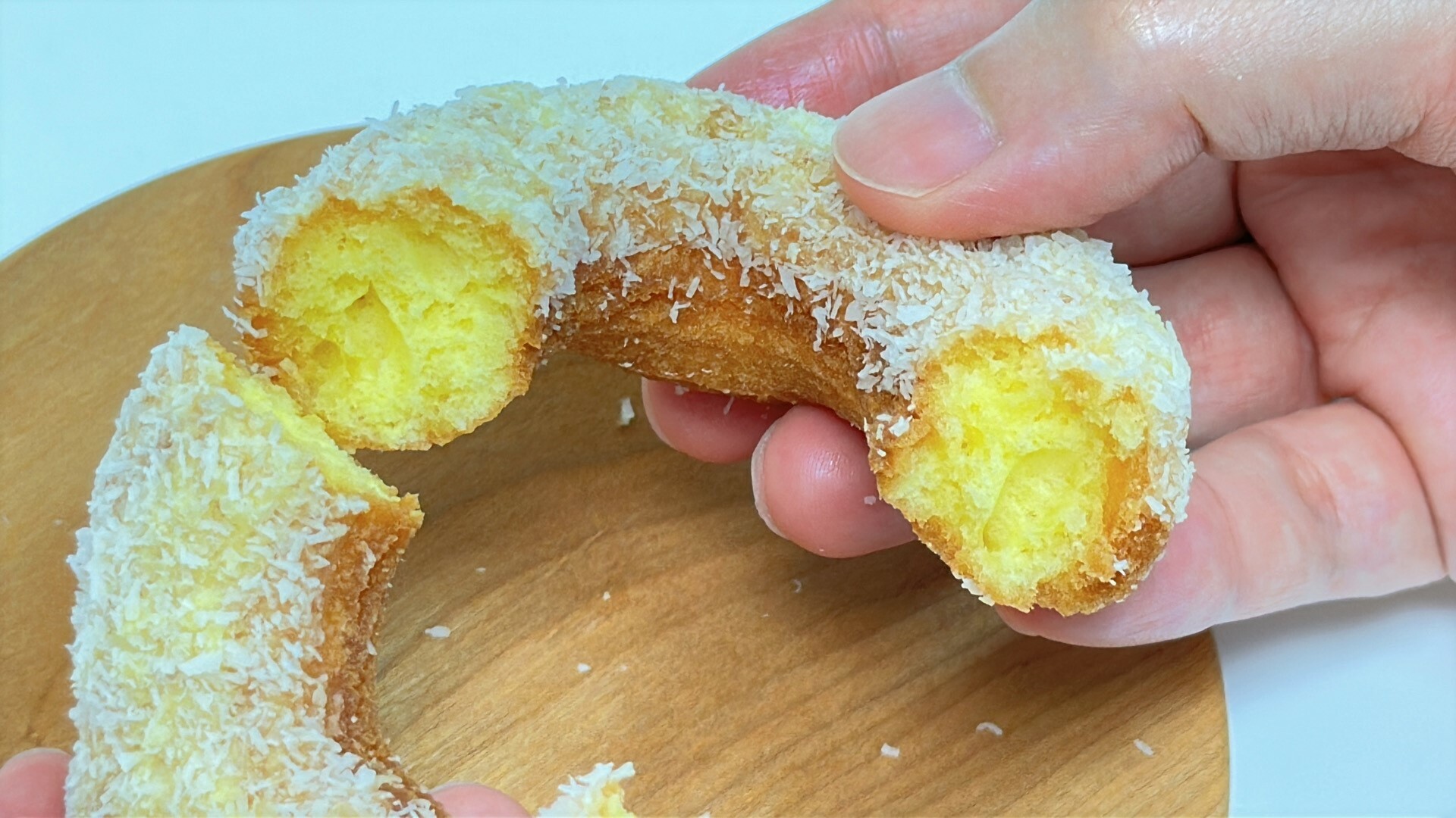 ファミマのパイン＆ココナッツドーナツを割ると鮮やかな黄色い断面が現れます