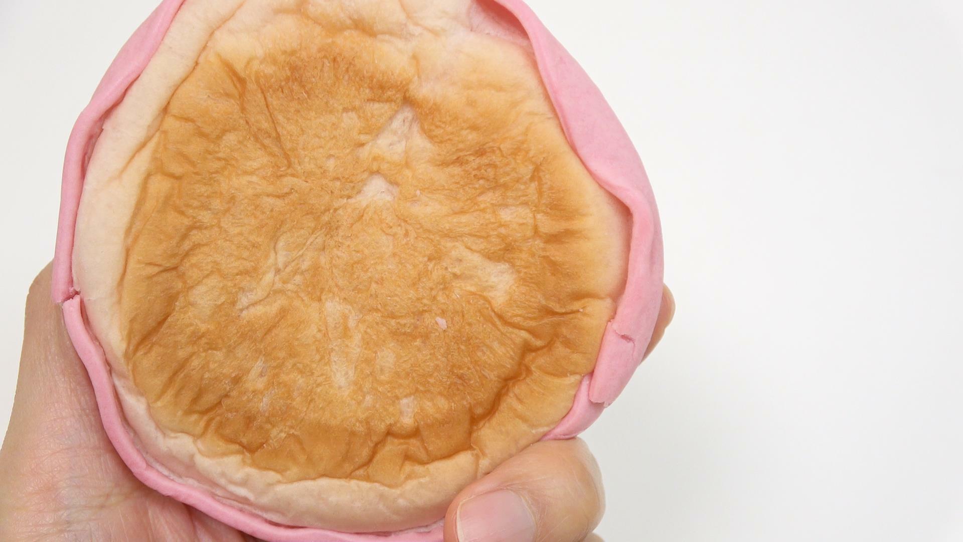 ピンクの生地がかぶさった新発売ファミマのもちっと食感のいちごパン