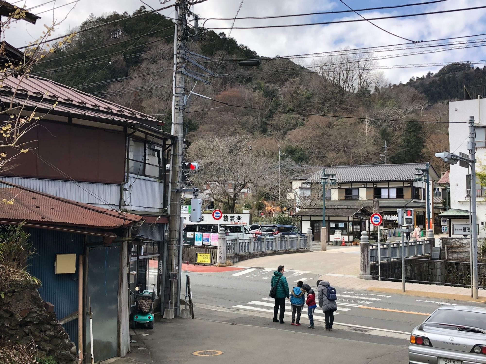 甲州街道への合流地点。信号を渡りまっすぐ進めば高尾山登山口へ、右手に進めば高尾山口駅です