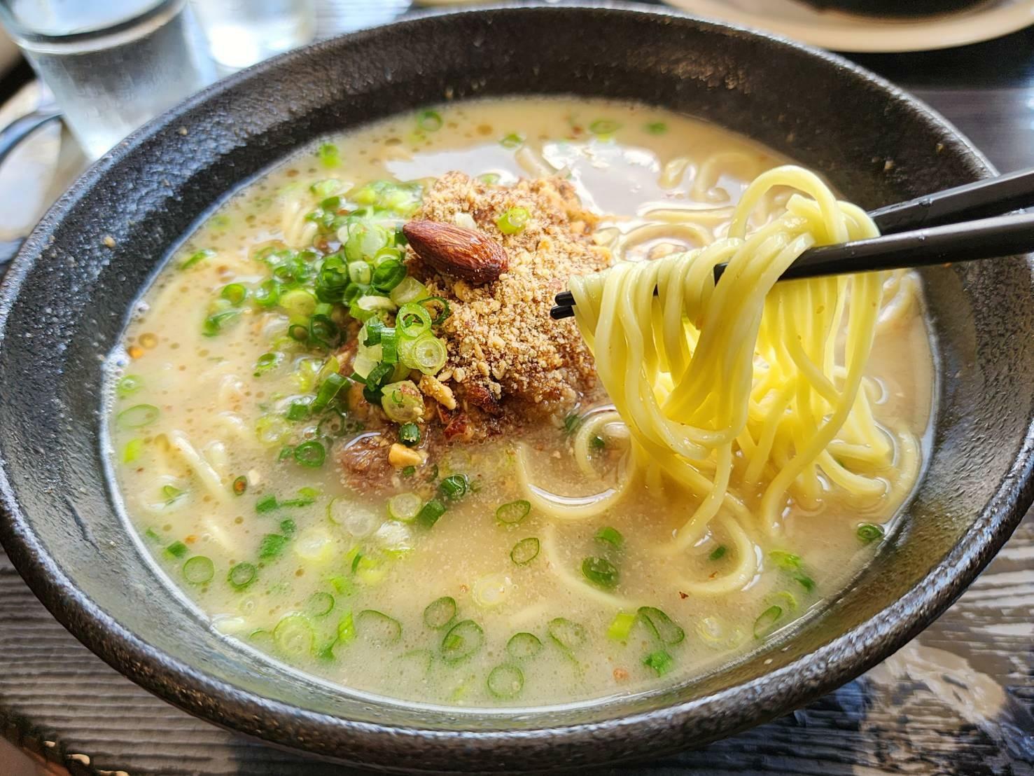 アーモンドラーメン。湧水町産のアーモンドをさまざまな形状、またアーモンドオイルにして入れたもの。鹿児島ラーメンの魅力を残しながら、独創的な一杯に仕上げている