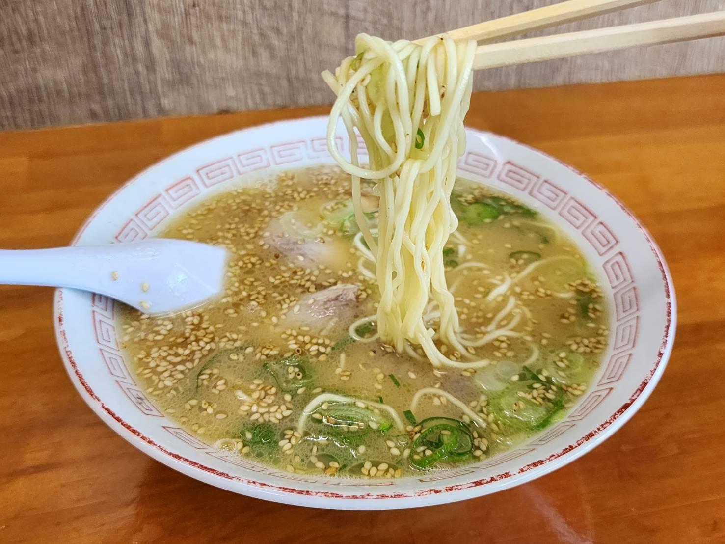 口の中で踊るような食感、コシのある特注麺。スープは塩気もバリッと効き、デフォルトでゴマが振り掛けられている