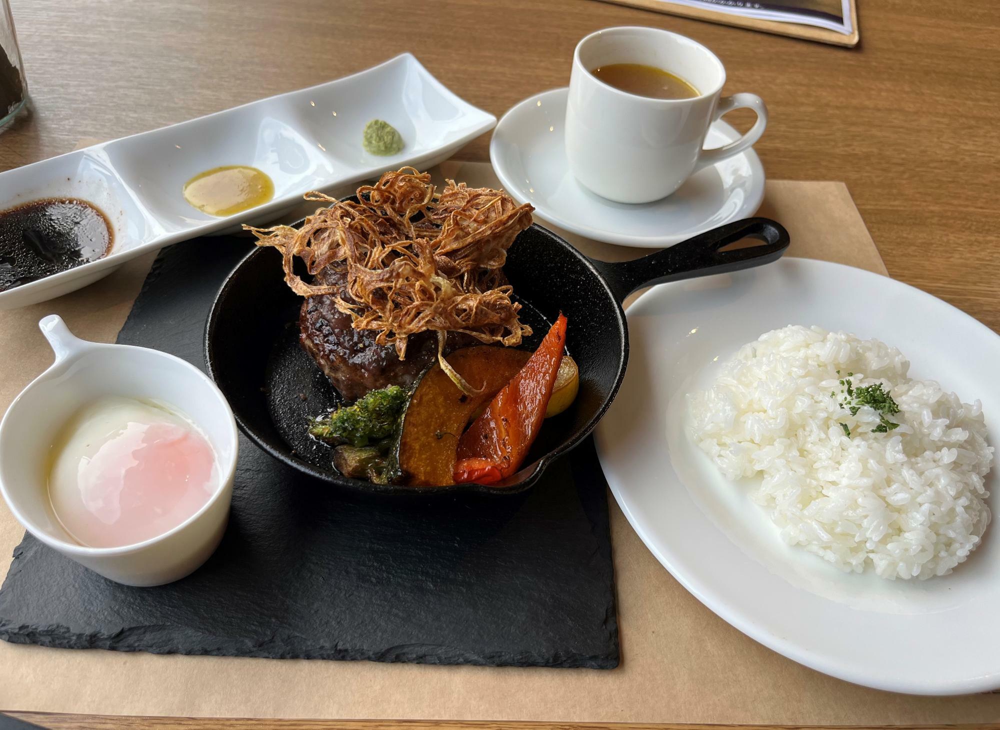 ハンバーグのほか、ライス、サラダ、スープが付きます。この日は和牛と香味野菜のスープ。ハンバーグには味変のこだわりのソースやワサビが付きます