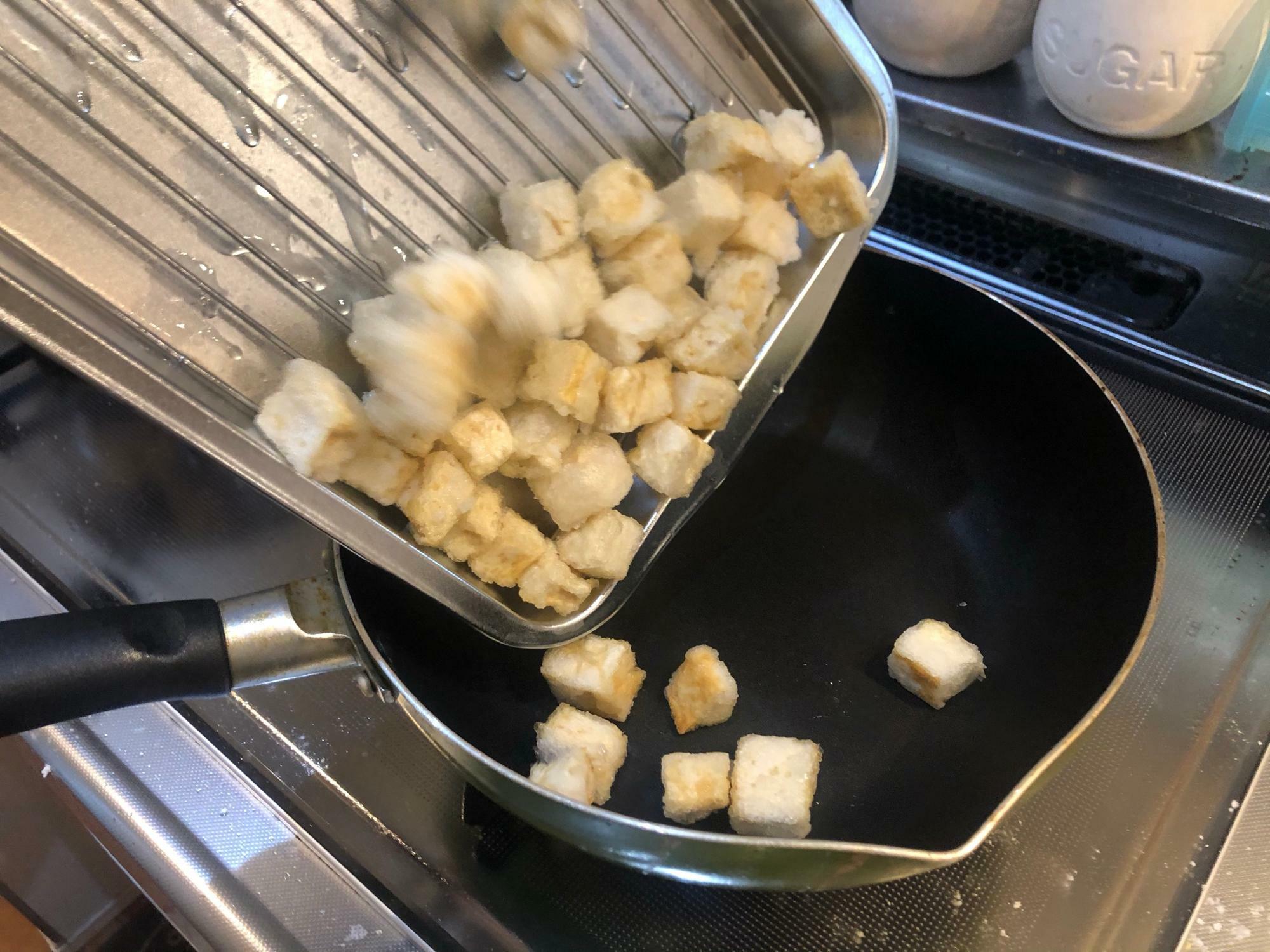 見ればわかりますが揚げた豆腐を油のないフライパンに戻し入れてます。