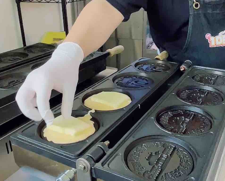 生地の上に大きなチーズをのせ、そのうえに生地を流して焼き上げます。