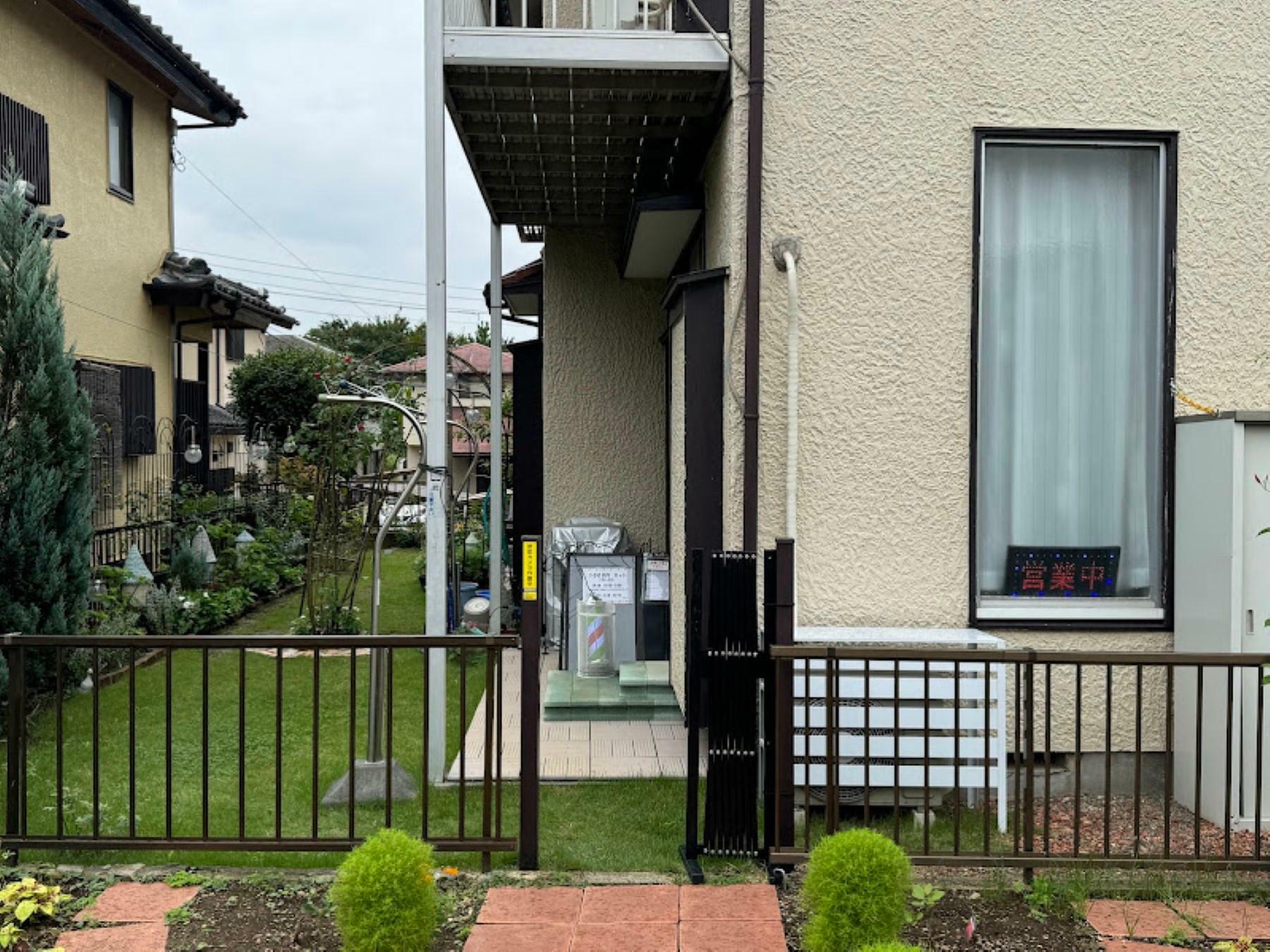 街路樹の所に店舗兼住居に続く道があります。