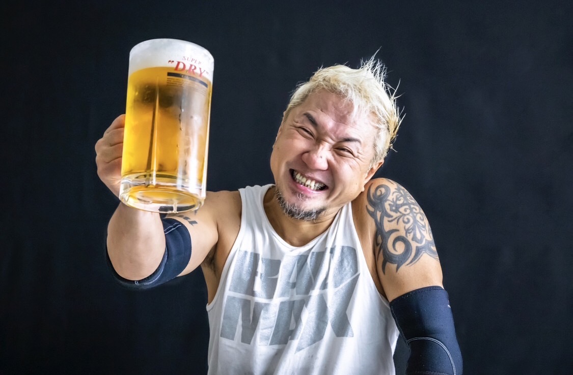 「筋トレビール！」を手にして、満面笑みのKOBEメリケンプロレス代表、BADMAX藤永さん