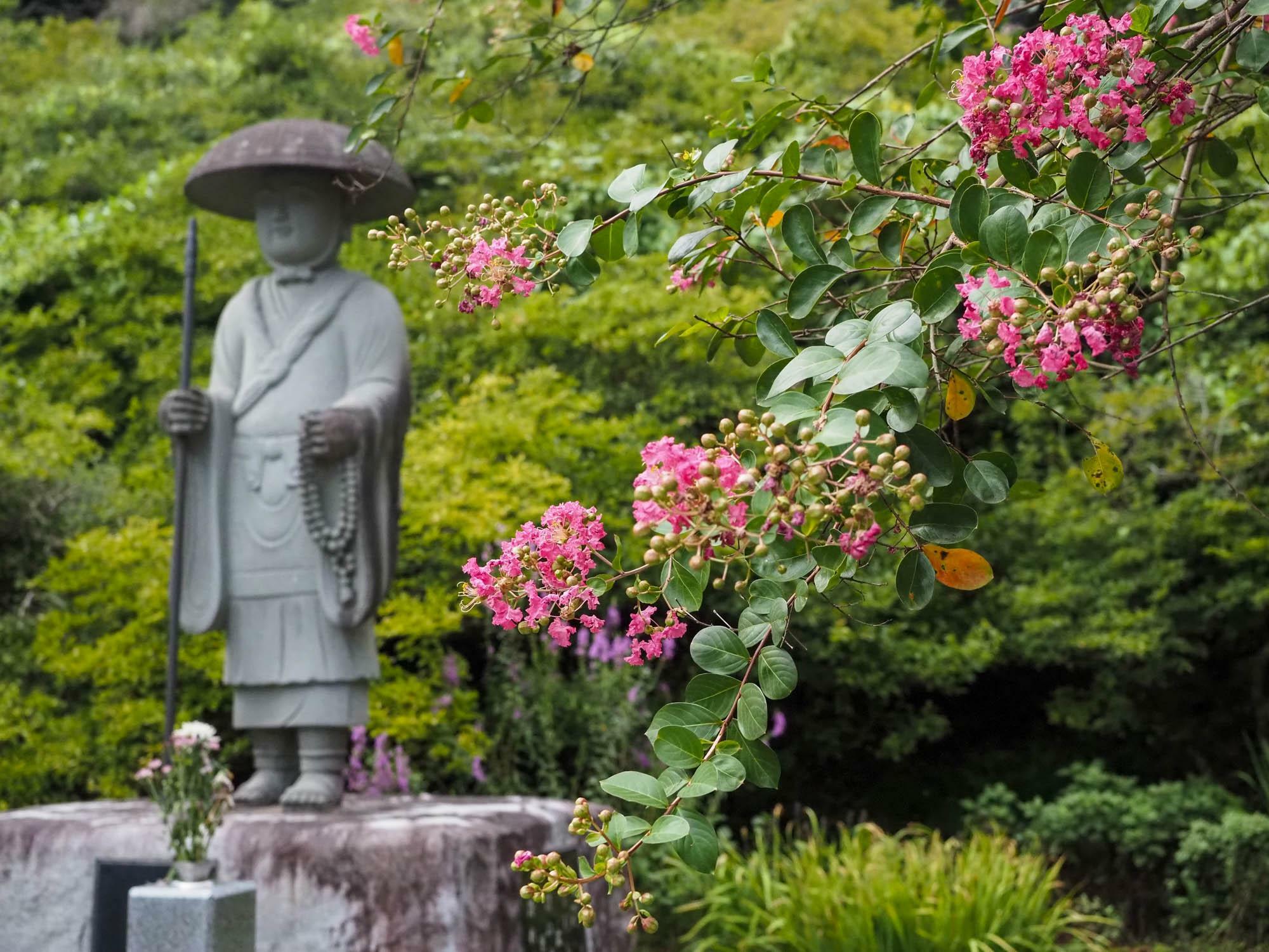 慈覚大師円仁の石像と境内を彩るサルスベリの花。円仁は9歳から6年間大慈寺にて修業したと伝えられる。(2024年8月20日撮影)