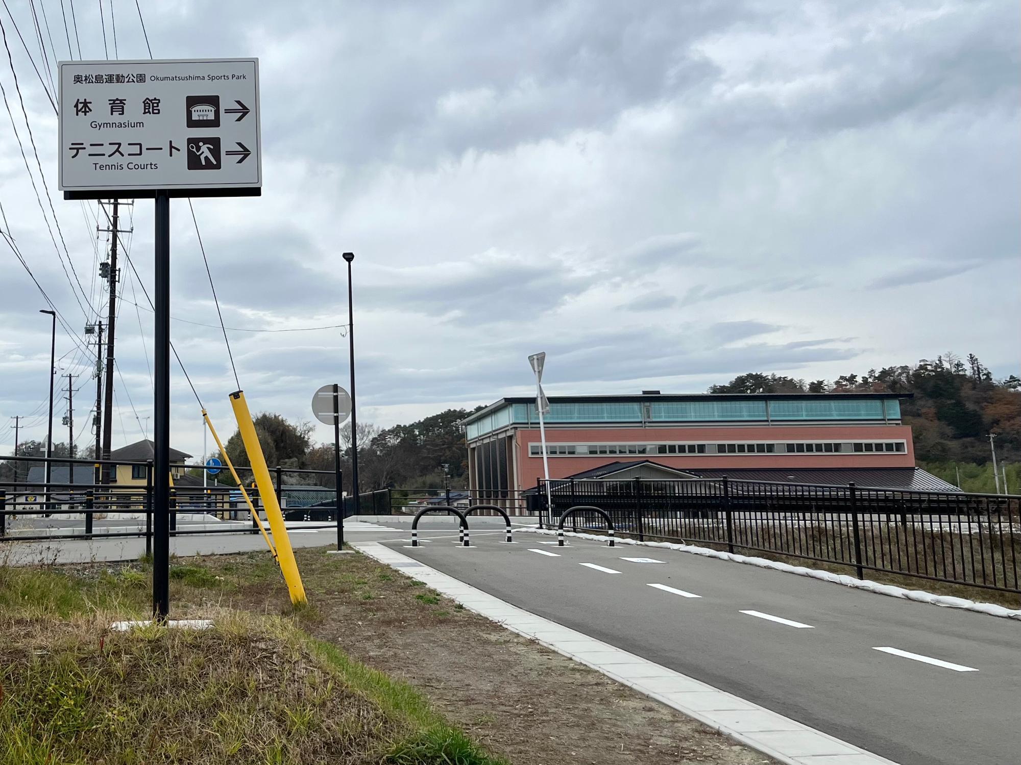 ▲ 写真の右奥にあるオレンジ色の建物が「奥松島運動公園体育館」だ。ここを目印にして農園へ行こう！