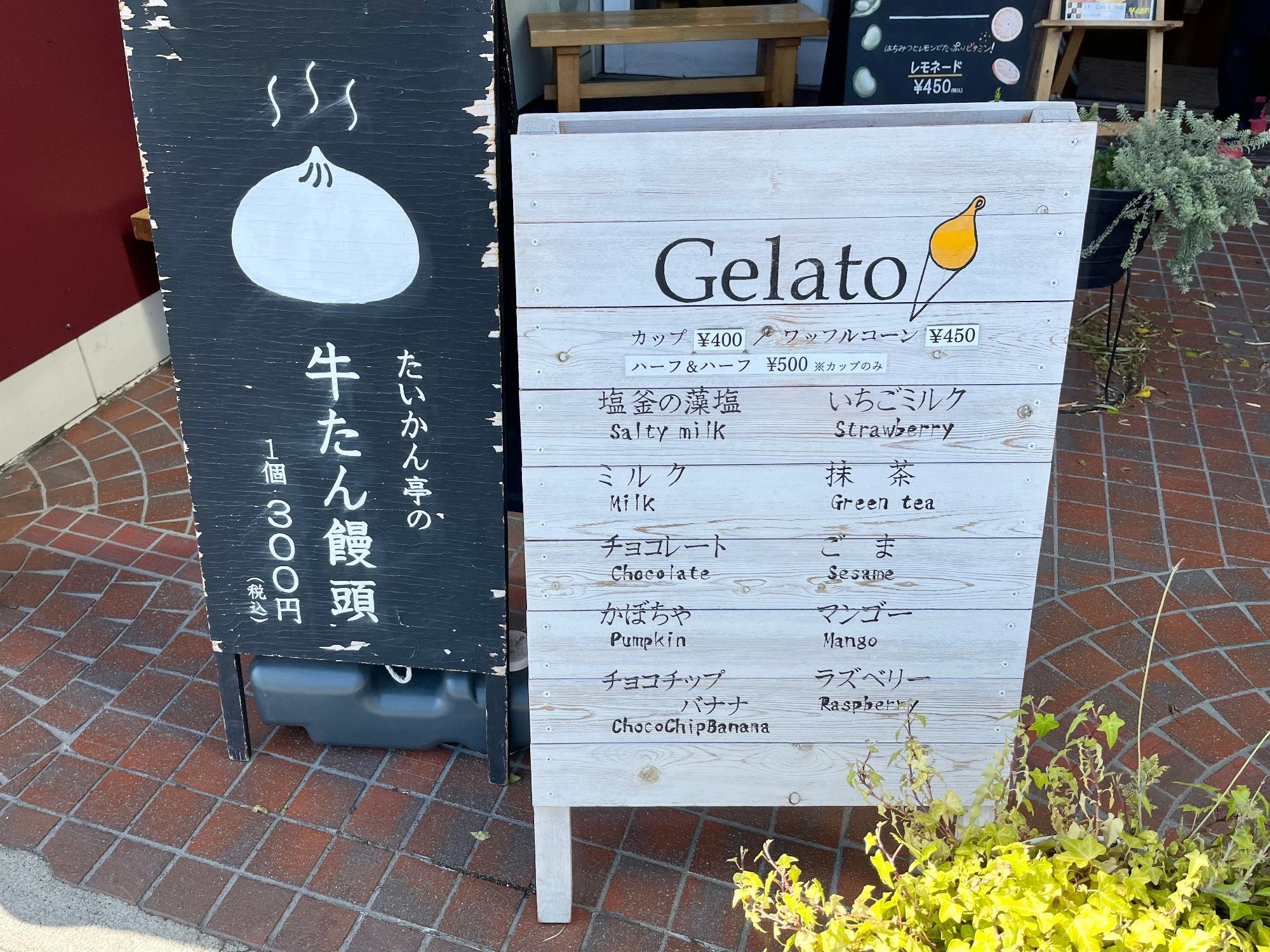 ▲ 写真向かって右側の看板がジェラートのメニュー。左側はもう一つの目玉商品「牛たん饅頭」の存在。しかし今回は「ジェラート」に注目していく！