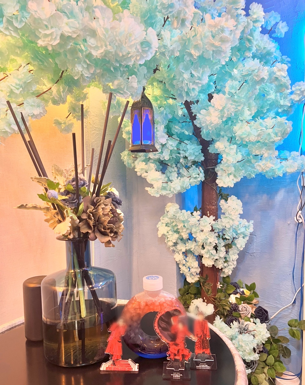 店内奥の青い花が咲く木の前で撮影
