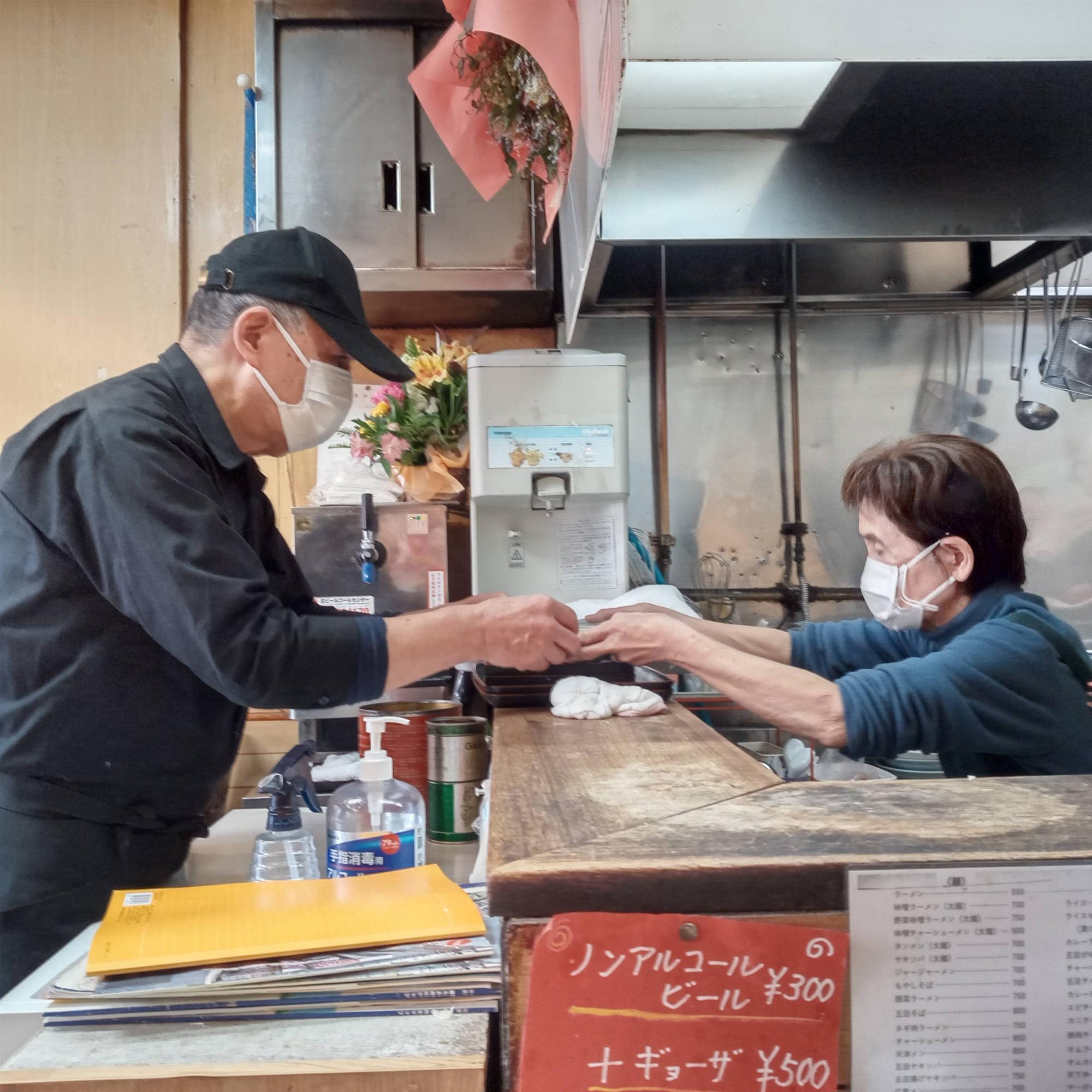 出来上がった料理の受け渡し。両手で丁寧に料理を渡し、丁寧に受け取る。時間にしては一瞬だが、気持ちがこもっている仕事とは、こういうことなんだな、と実感。夫婦のコンビネーションもさすが