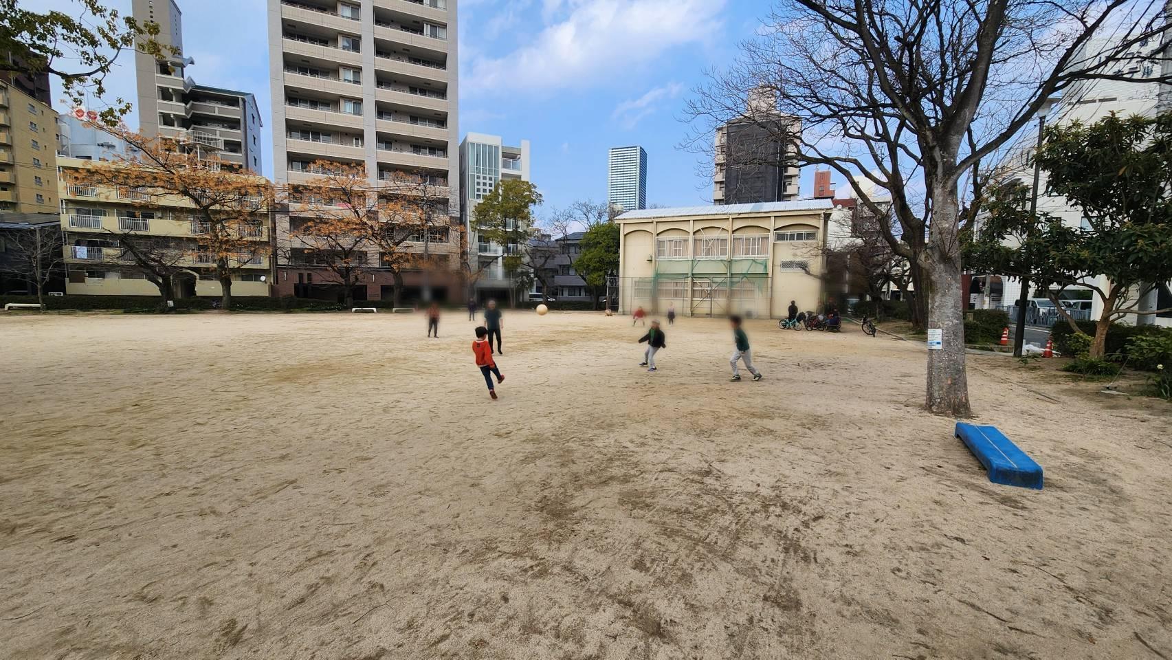 公園内でサッカーをして遊ぶ子どもたち