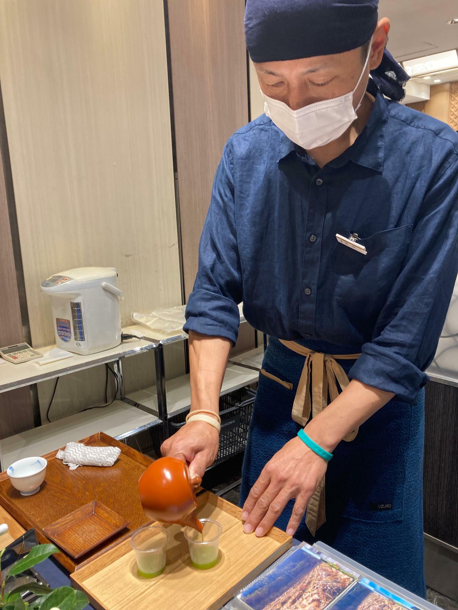 日本橋三越地下一階に期間限定で出店している高塚さんを訪ねました。丁寧に試飲用のお茶をいれる姿。茶葉によっていれ方を変えて提供しているそうです　※許可いただいた上取材しております