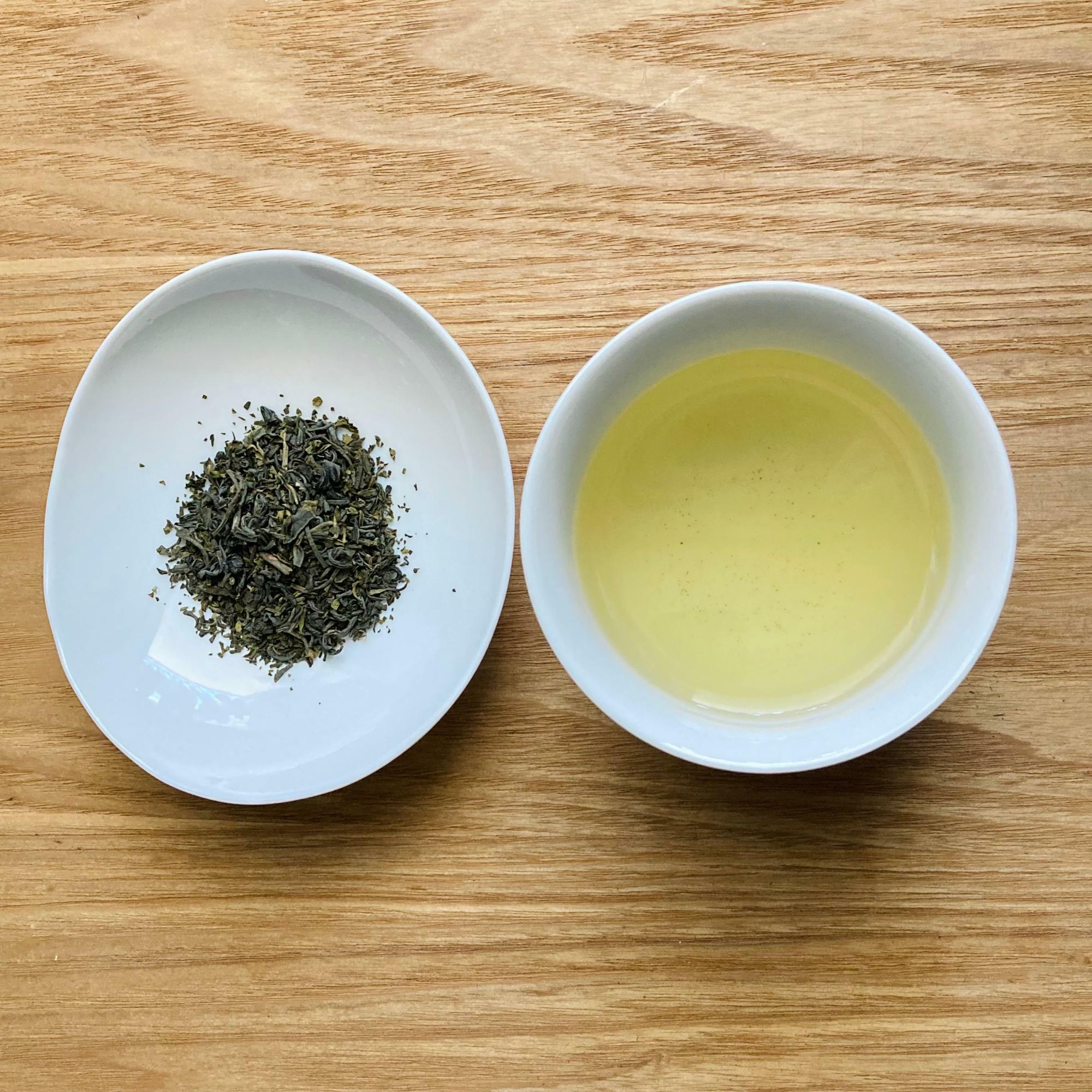釜炒り製法のべにふうき緑茶の茶葉（左）と急須でいれたお茶（右）