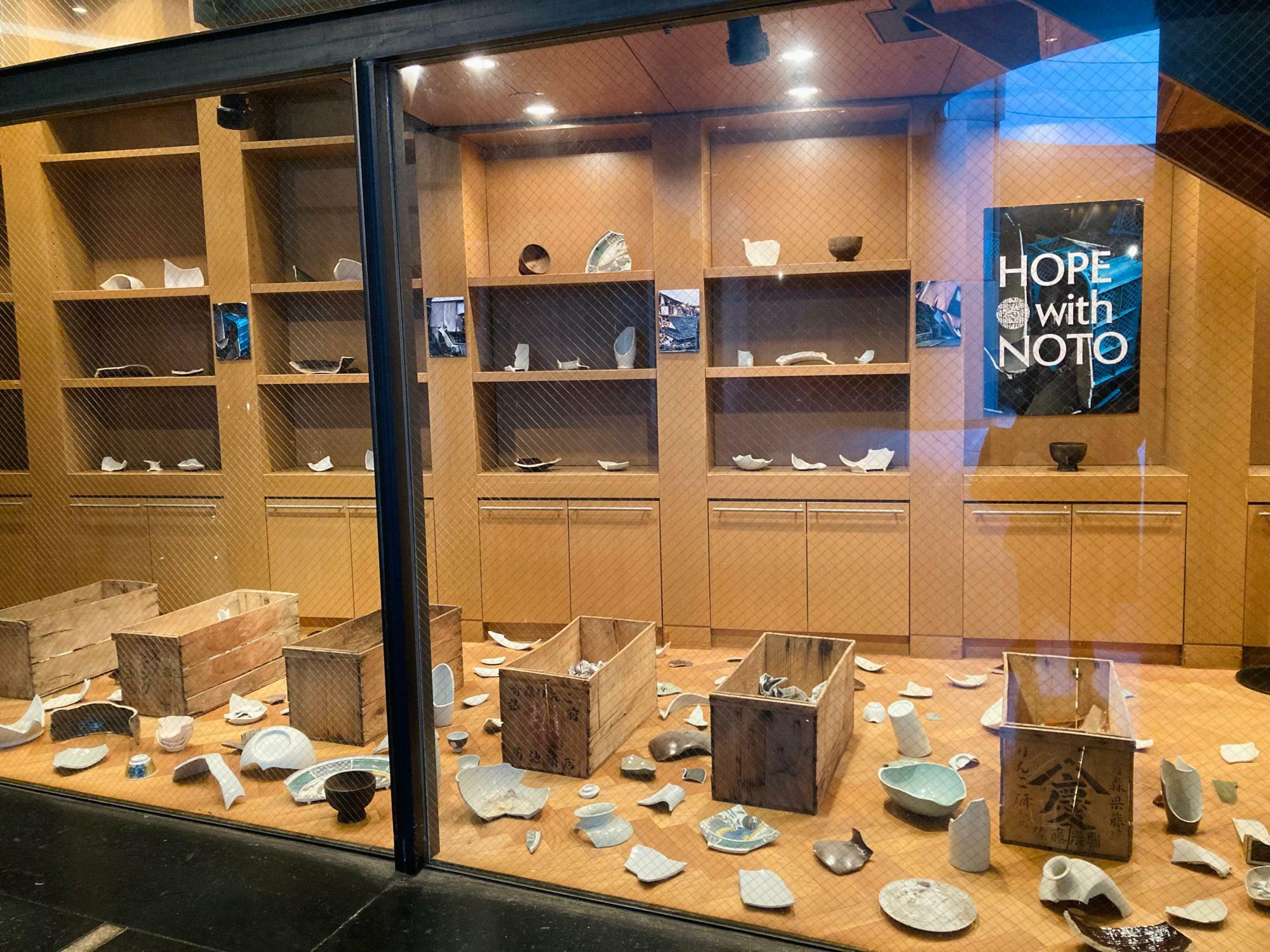 渋谷bunkamuraブックストアでの「HOPE with NOTO」の展示。能登半島地震で割れた九谷焼の器や、埃や土をかぶってしまった輪島塗の漆器、被災地の写真が展示されている
