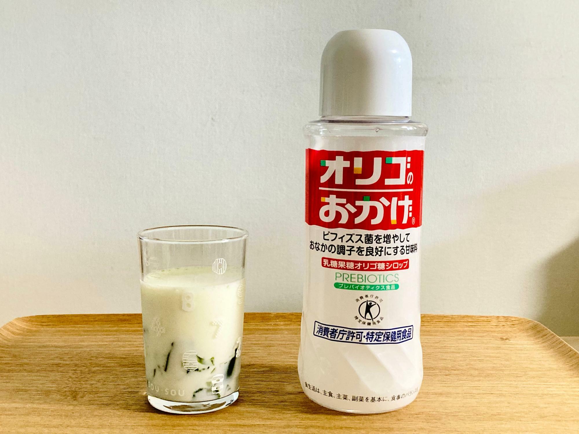 抹茶ゼリーに牛乳を注いだ状態。右はオリゴ糖シロップ「オリゴのおかげ」。スーパーで買えます。