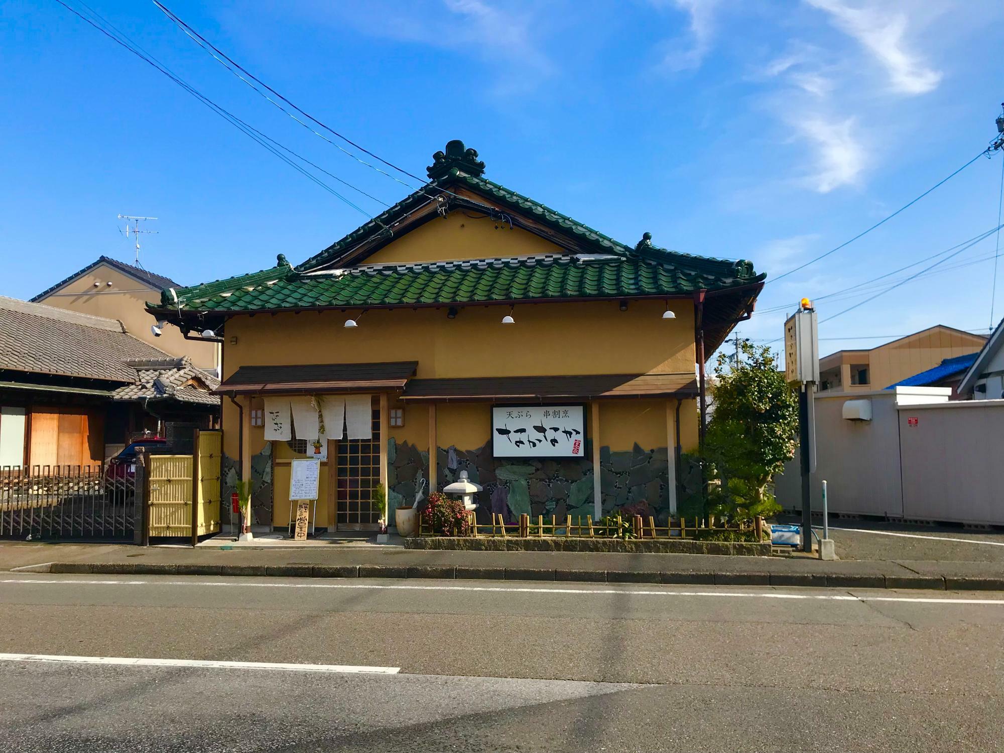 こじんまりとした緑色の瓦葺屋根の日本家屋の外観