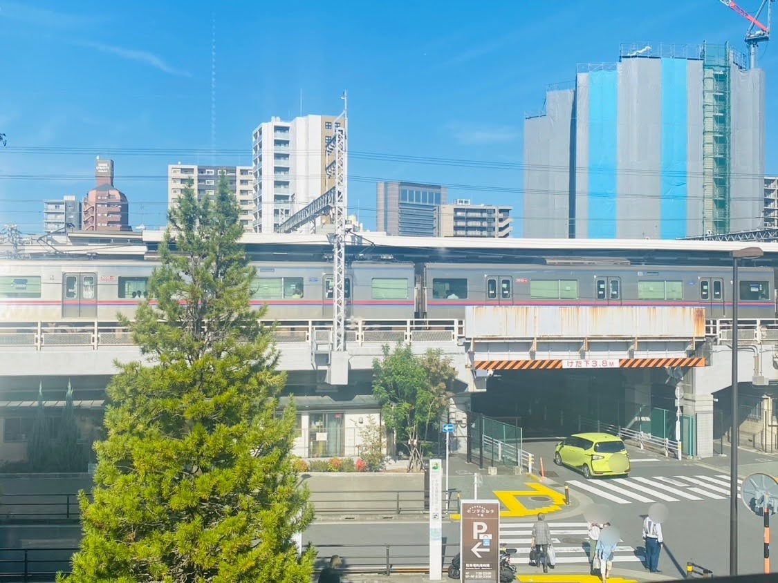 窓の向こうには、京成線「千住大橋」駅のホーム