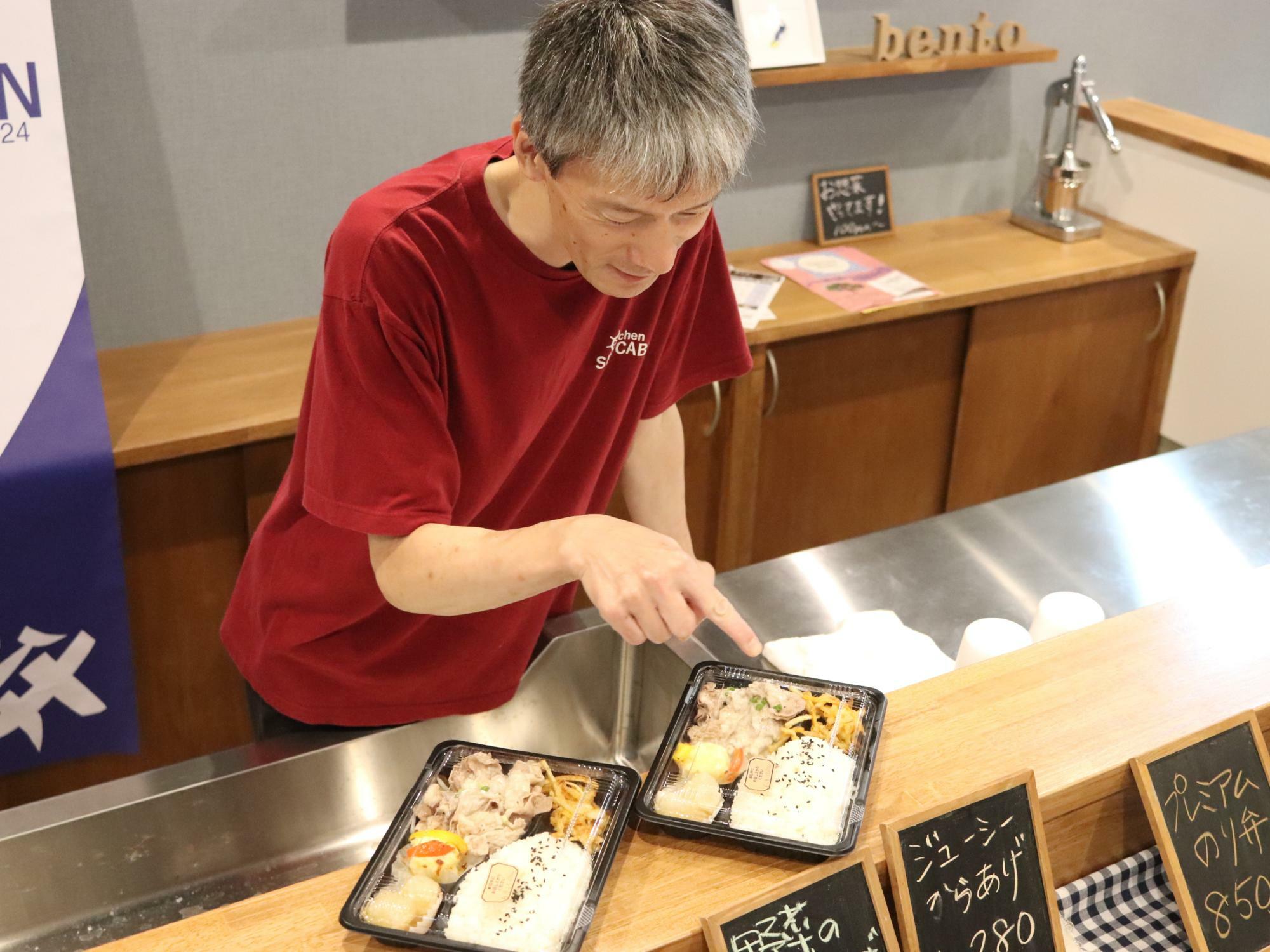 お弁当のおかずの特徴を教えてくれている店主