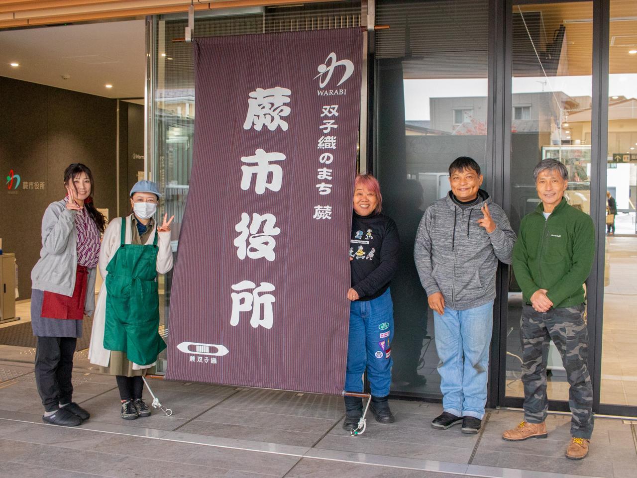 蕨市役所の前で笑顔とポーズを決めてくれた笑美キッチンカー協会のみなさん