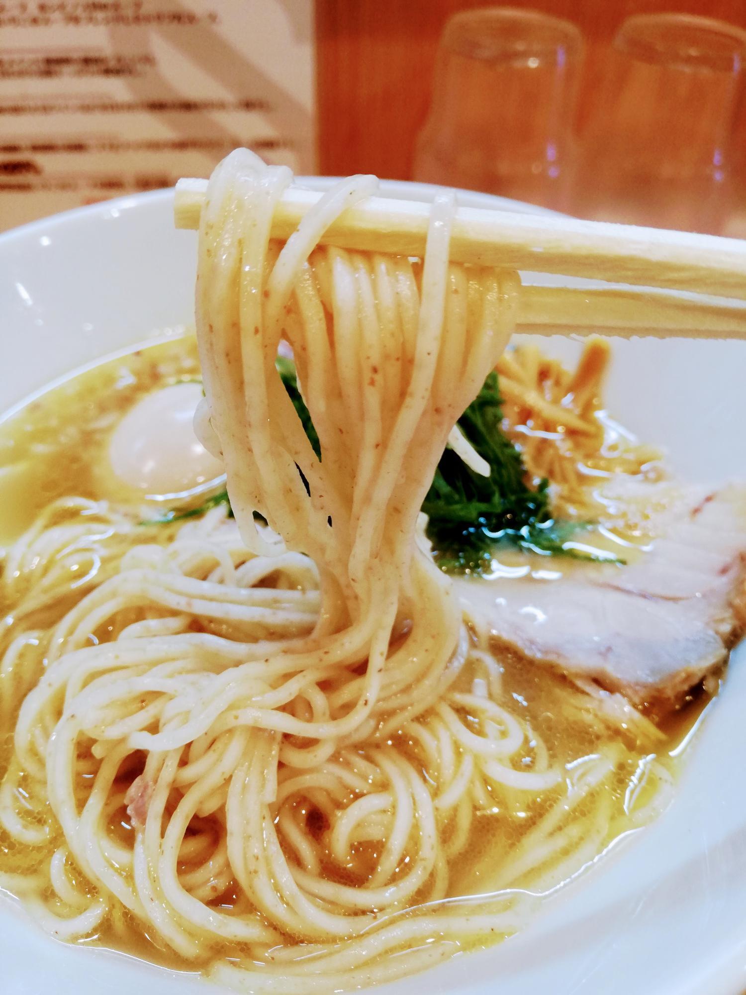 輝くスープからの黄金の細麺