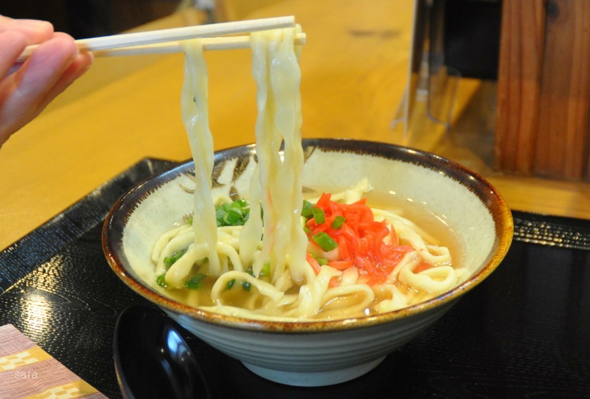 地域により麺の形状が異なる沖縄そば。この揉みが入った平麺で育った與那覇さんの思い入れはひとしお。食べ応えばっちり、ご家族でお腹いっぱい満たされて。 写真は「素そば」（500円）。