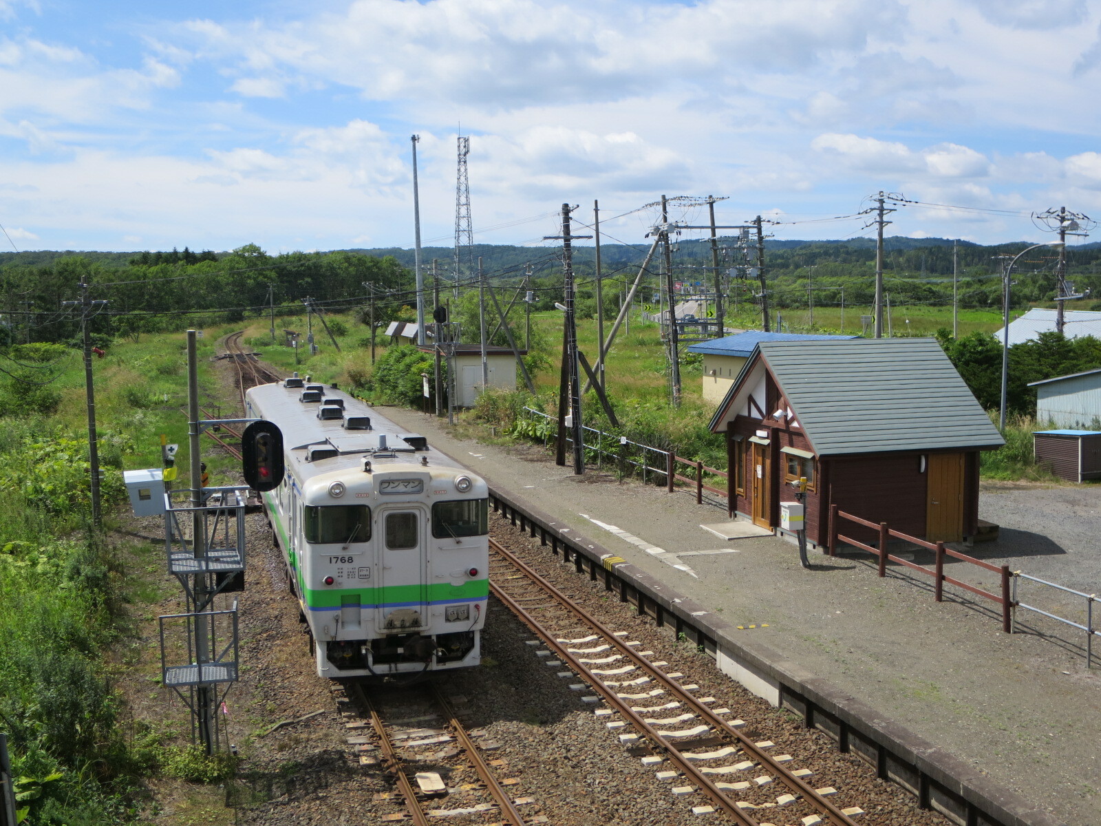 跨線橋から見た駅舎と上り列車