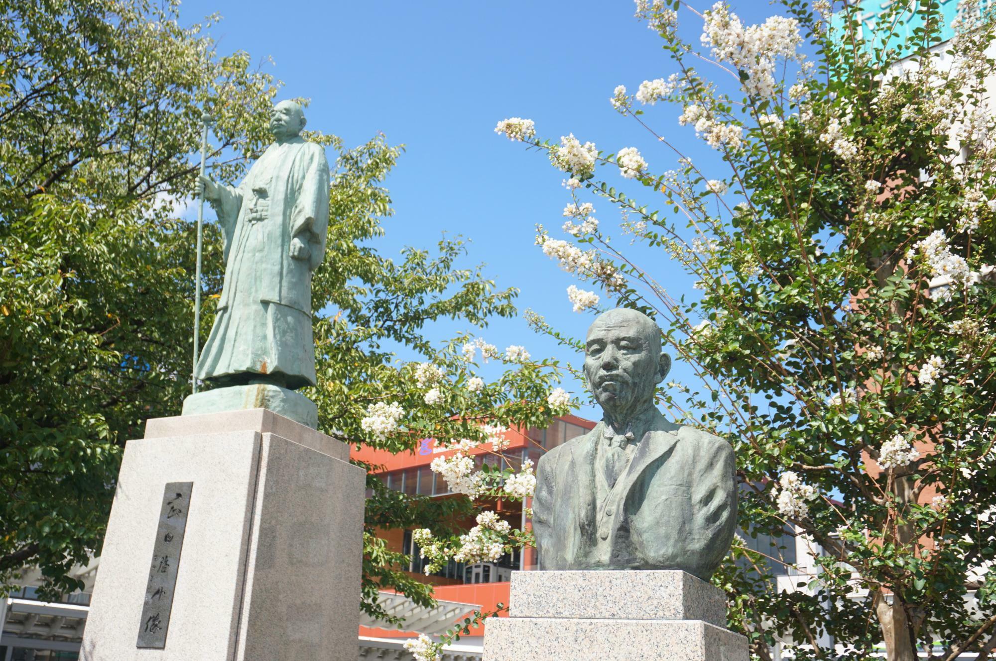 岡田啓介の像（左）と松尾伝蔵の胸像（右）