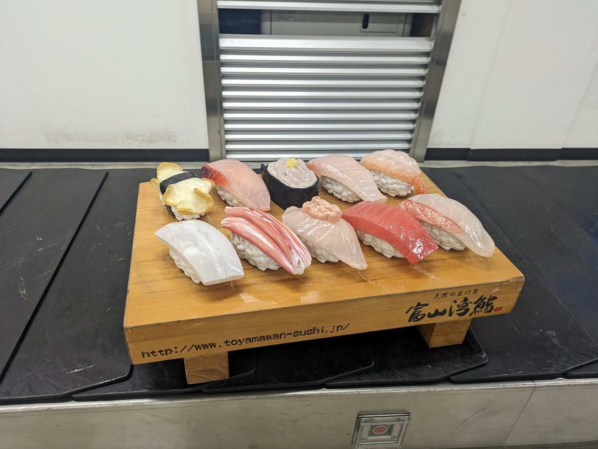 富山空港のターンテーブルには富山湾鮨が流れています。