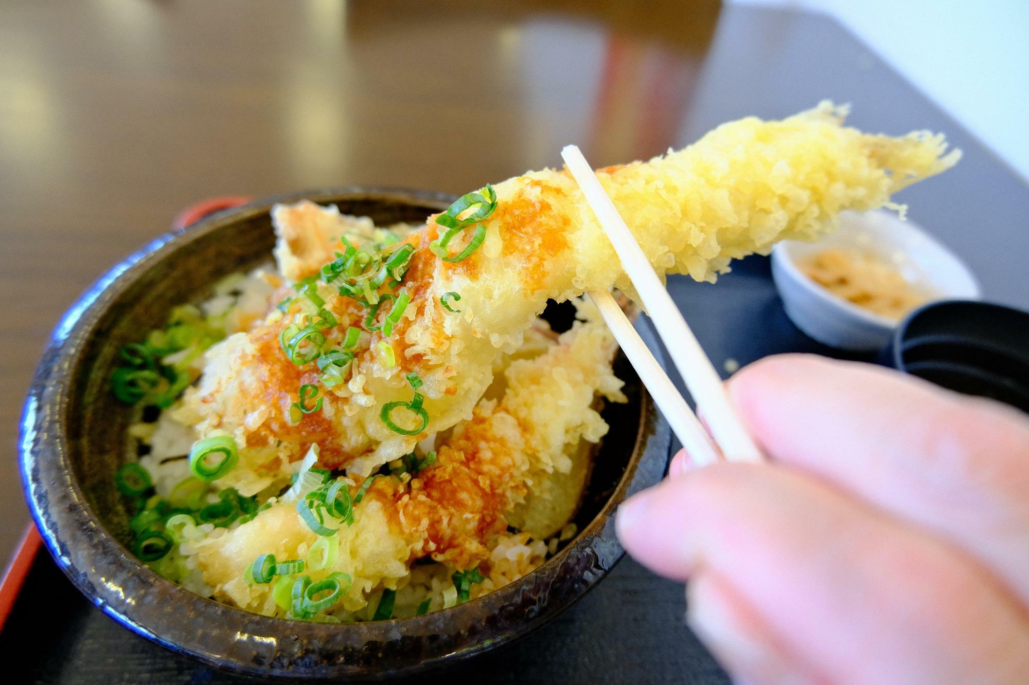 丼から優にはみ出る長さの穴子の天ぷらをひょいっと持ち上げて…