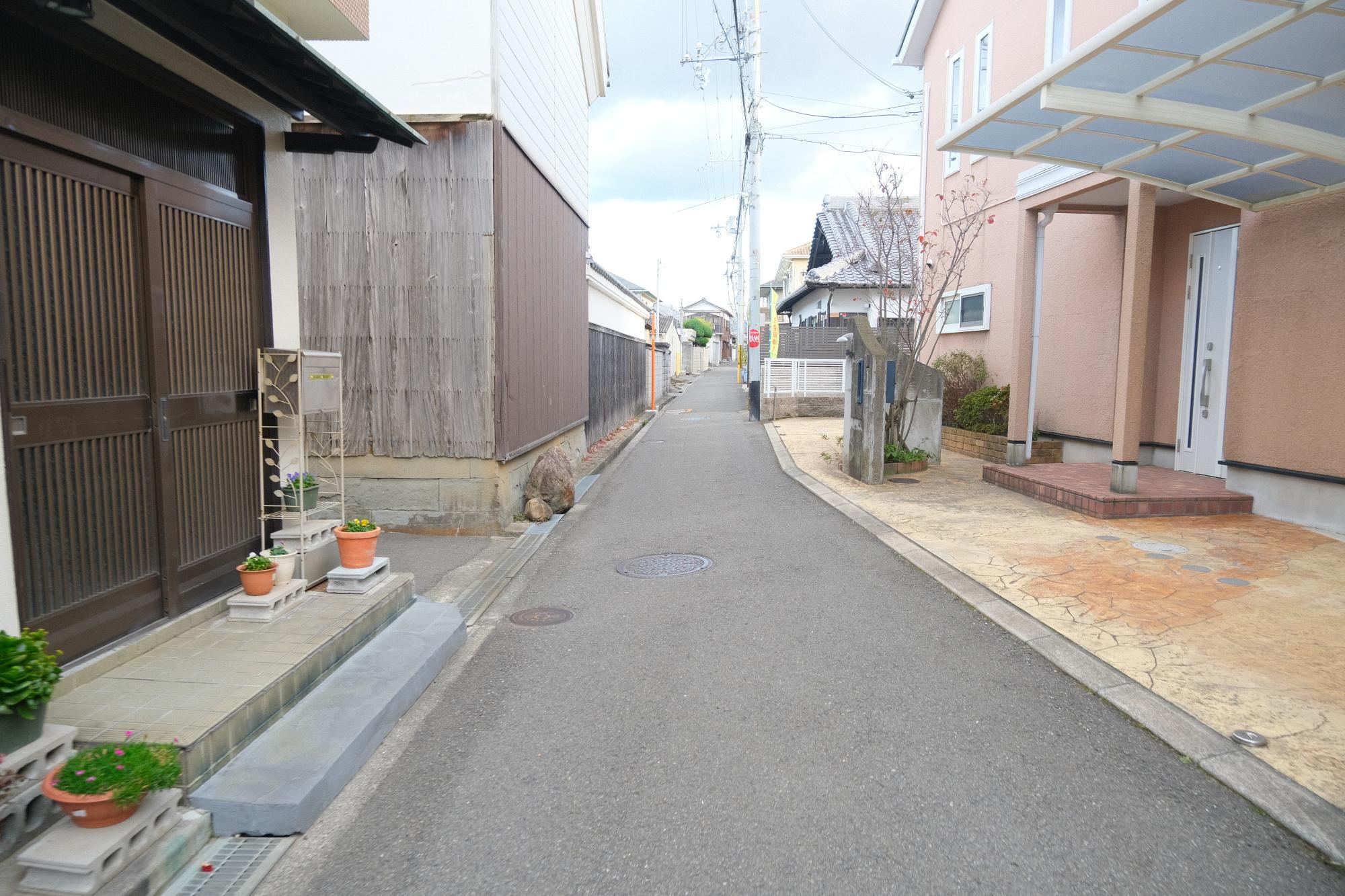 府道63号線(海側)から西信達小学校へ続く道。道幅も狭く、古い木造住宅やブロック塀が多い