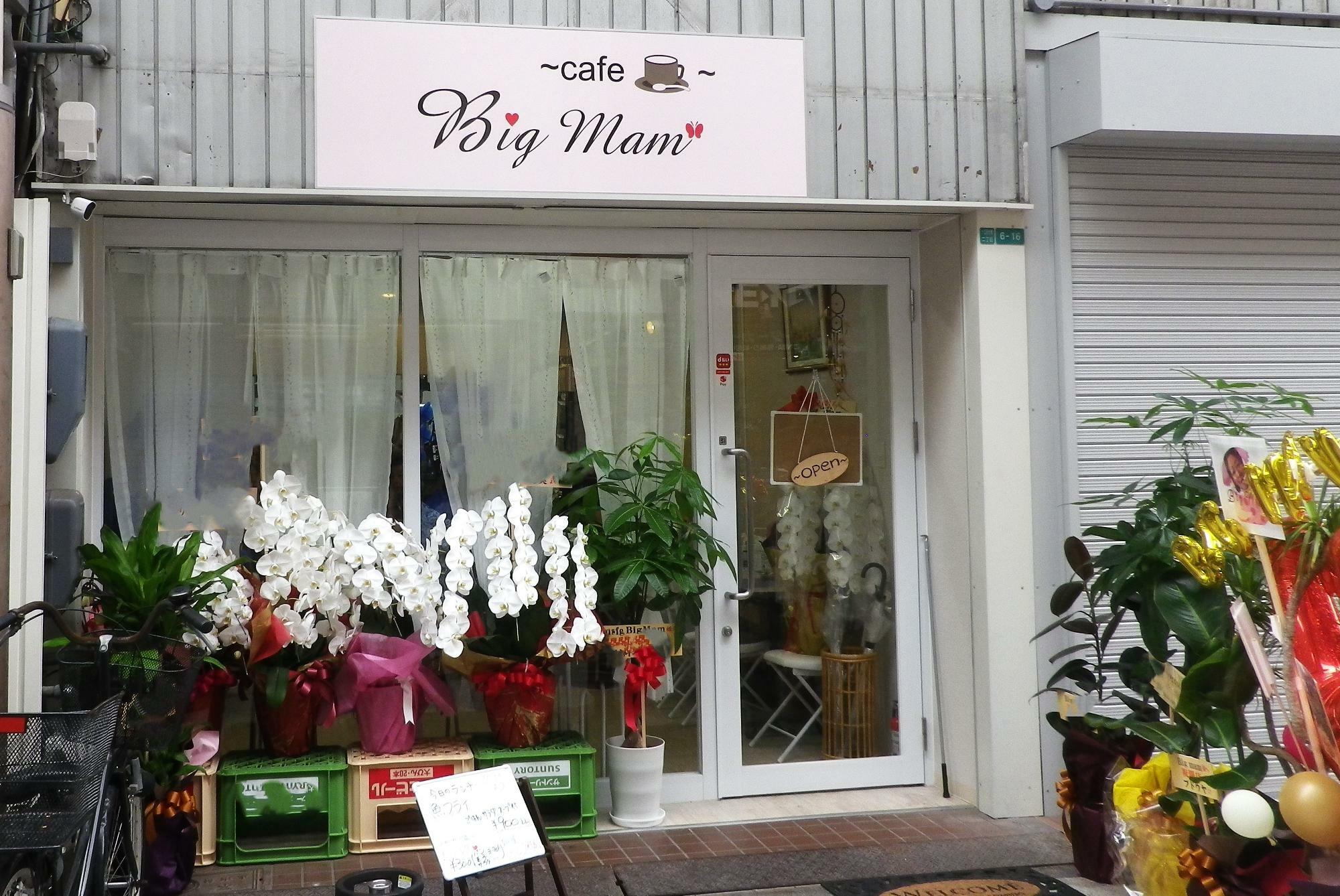 オープンの祝花が並ぶ白いお店。